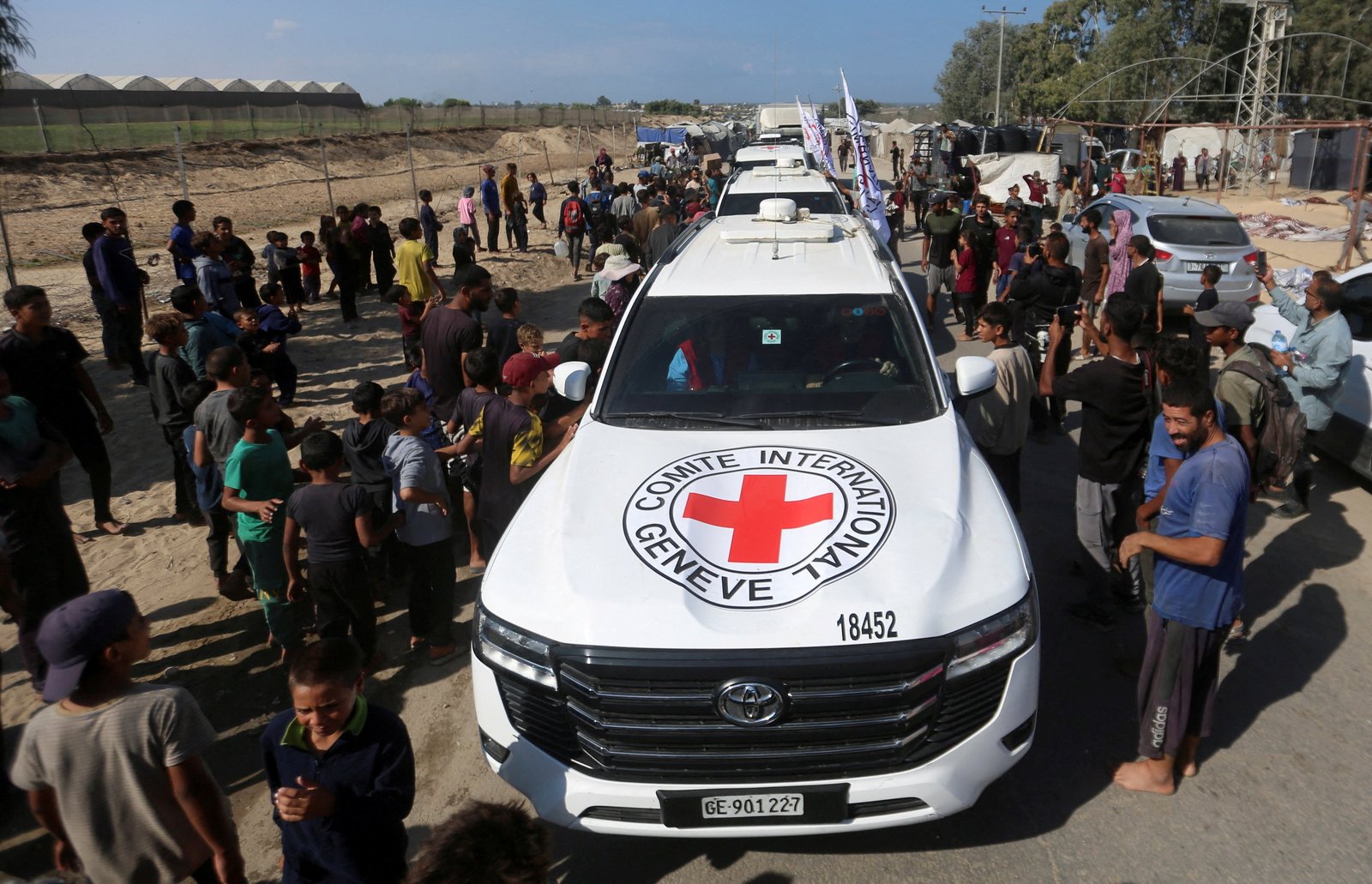 Palestinians gather around Red Cross vehicles transporting hostages in the central Gaza Strip, Oct. 13, 2025, held in Gaza since the deadly Oct. 7, 2023 attack, following their handover as part of a ceasefire and hostages-prisoners swap deal between Hamas and Israel. (OSV News photo/Reuters)