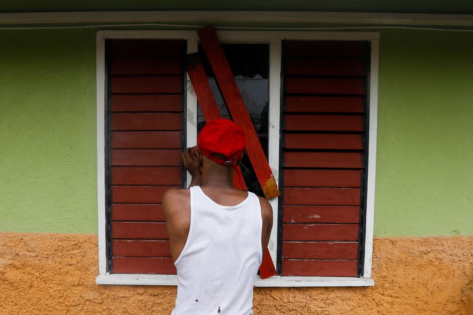 A man boards up a window, in preparation for the arrival of Hurricane Melissa in Port Royal, Jamaica, Oct. 26, 2025. Hurricane Melissa intensified to Category 5 strength Oct. 27 as it neared Jamaica with up to 30 inches of rain and a life-threatening storm surge. (OSV News photo/Octavio Jones, Reuters)