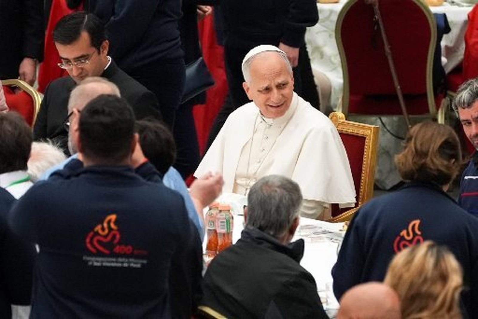 El Papa León XIV sonríe mientras comparte almuerzo con personas asistidas por organizaciones benéficas eclesiásticas en el Salón de Audiencias Pablo VI del Vaticano el 16 de noviembre de 2025. (Foto CNS/Lola Gomez)