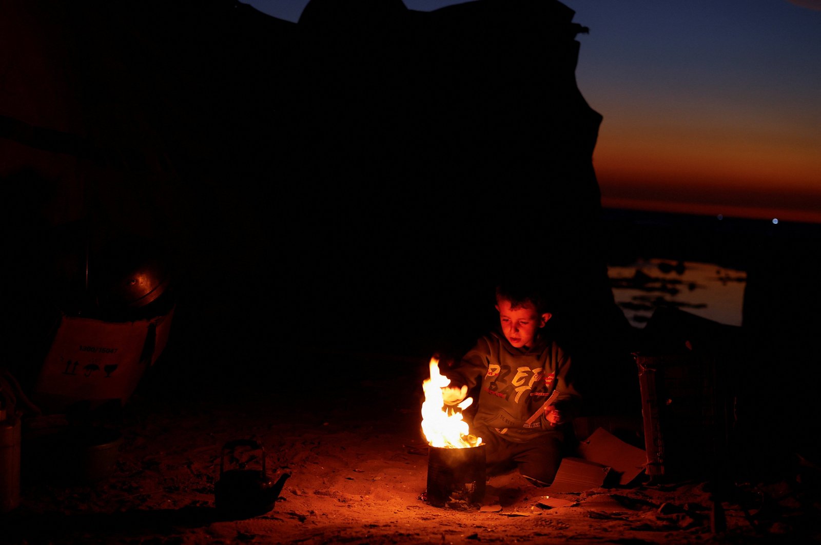 Palestinians sit near a tent that stands next to debris, amid a ceasefire between Israel and Hamas, in Gaza City, Nov. 17, 2025. (OSV News photo/Dawoud Abu Alkas, Reuters)