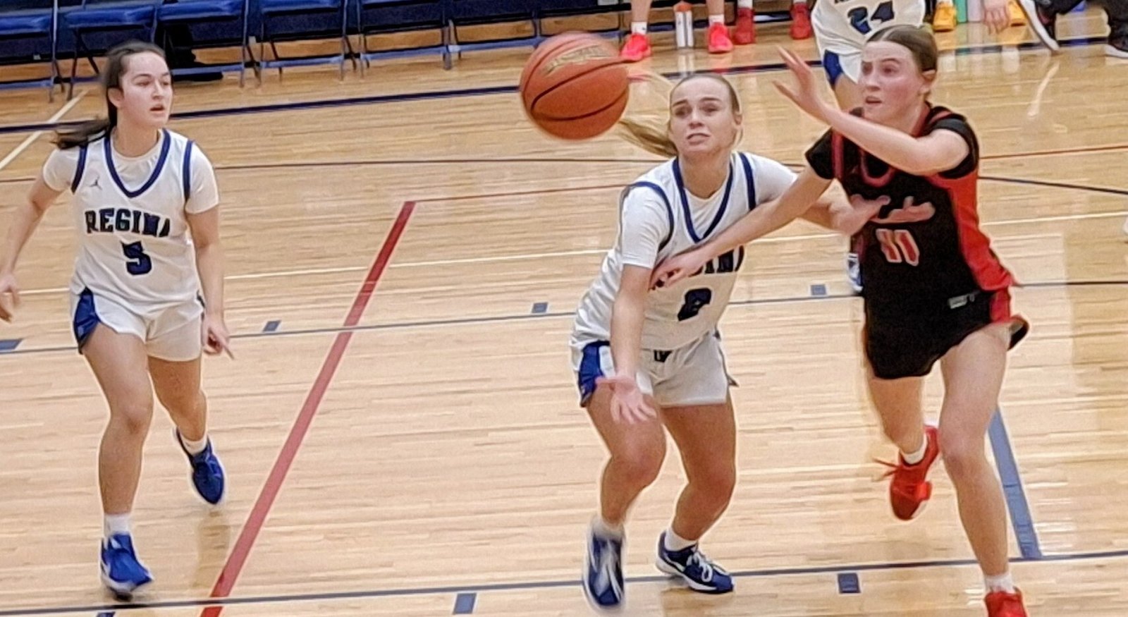 Regina’s Mattie Houth (5) awaits the outcome of a scramble for a the ball between teammate Emersen Holder and St. Mary’s Jessica Asmussen. St. Mary’s won the game 47-43. (Photo by Don Horkey | Special to Detroit Catholic)