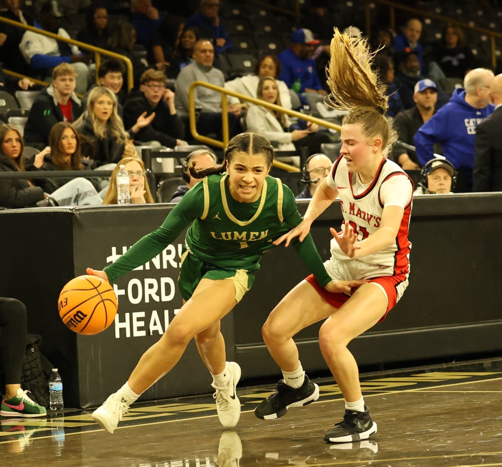 St. Mary’s Jessica Asmussen finds it’s a hair-raising event to guard Lumen Christi’s phenomenal sophomore Kenna Hunt. Hunt scored 22 points including the last six to save Lumen Christi’s 48-36 victory for the CHSL Girls Bishop Division basketball championship.  (Photo courtesy of Rick Bradley)