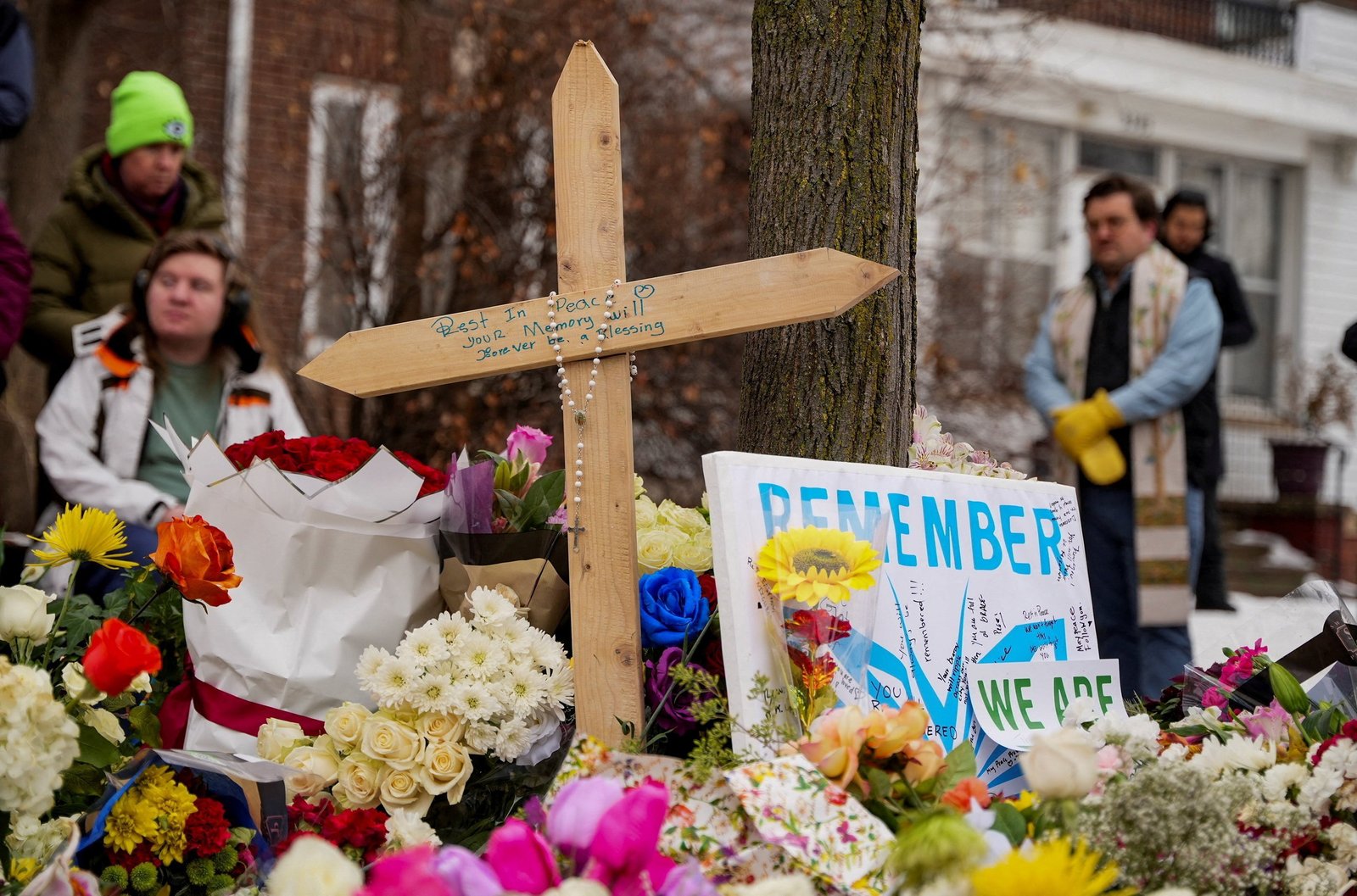 A rosary is draped over a cross as people gather by a makeshift memorial in Minneapolis Jan. 8, 2026, at the scene of the fatal shooting of Renee Nicole Good by a U.S. Immigration and Customs Enforcement agent. The 37-year-old protester was shot in her car Jan. 7, according to local and federal officials. They said an agent shot her in self-defense when she tried to run over him. (OSV News photo/Tim Evans, Reuters)