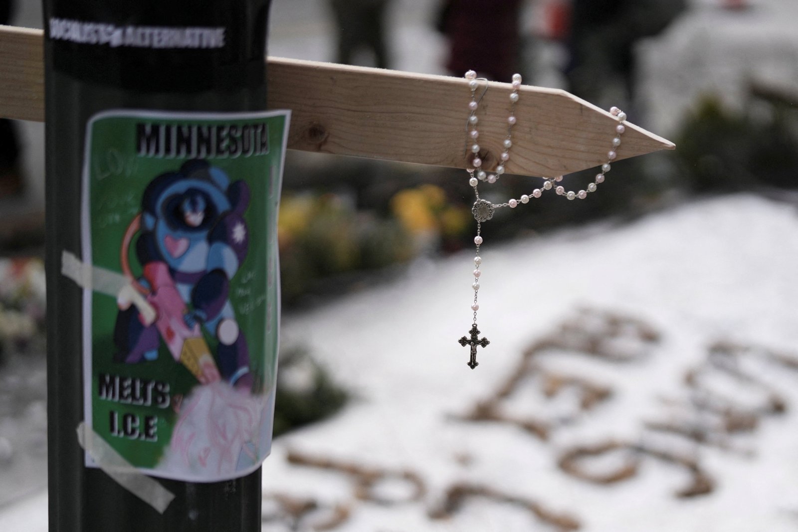 A rosary hangs from a cross at a makeshift memorial in Minneapolis Jan. 25, 2026, at the site where a man was fatally shot by federal agents trying to detain him. The Department of Homeland Security said Alex Pretti, a 37-year-old intensive care unit nurse, had a handgun and approached Border Patrol officers during a targeted operation Jan. 24. (OSV News photo/Tim Evans, Reuters)
