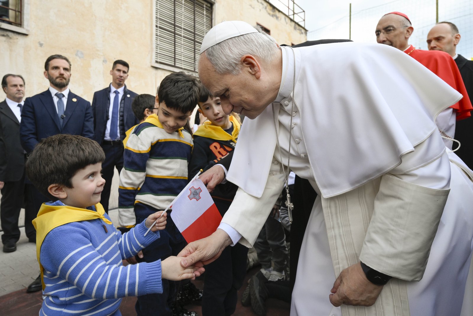 El Papa León XIV saluda a un niño que sostiene la bandera de Malta durante una visita parroquial a la Iglesia del Sagrado Corazón de Jesús en Roma, Italia, el 15 de marzo de 2026. (Foto CNS/Vatican Media)