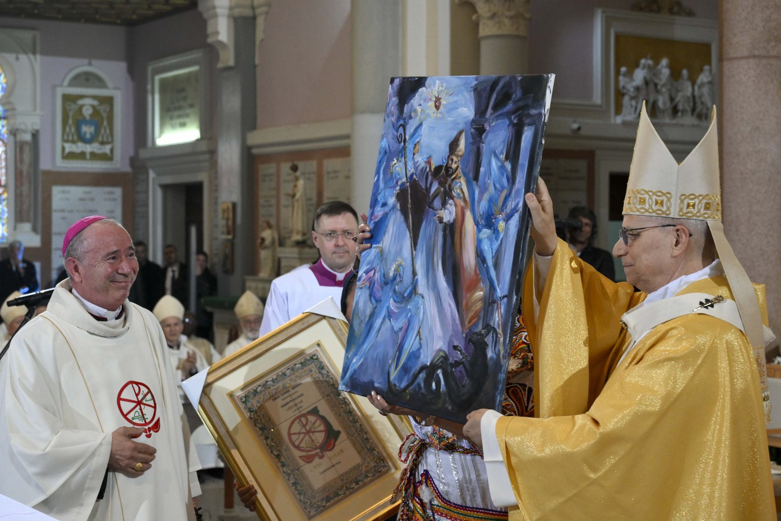 El Papa León XIV sostiene una pintura tras celebrar la misa en la Basílica de San Agustín, en Annaba, Argelia, el 14 de abril de 2026. A la izquierda, sonríe el obispo Michel Guillaud. (Foto de OSV News/Simone Risoluti, Vatican Media)