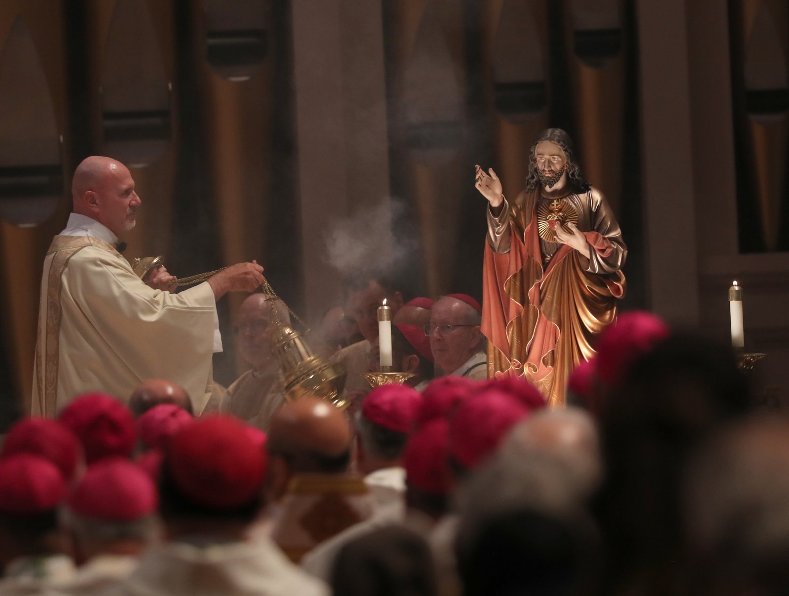 A clergyman swings a censer near a statue of the Sacred Heart of Jesus as U.S. Catholic bishops consecrate the country to the Sacred Heart at the Basilica of Mary Queen of the Universe in Orlando, Fla., June 11, 2026, during their spring plenary assembly. (OSV News photo/Bob Roller)