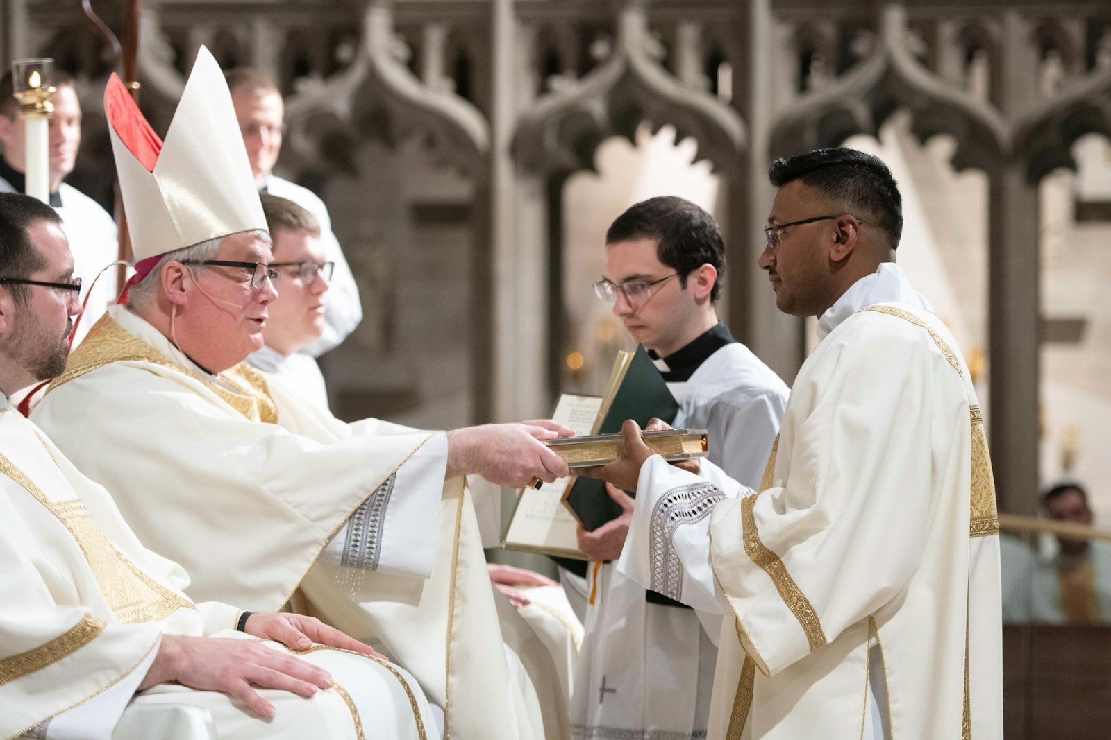 El Obispo Battersby le entrega el libro de los Evangelios al entonces Diácono Michael Bruno Selvaraj después de ordenarlo al diaconado transitorio el 23 de abril de 2022, en la Cathedral of the Most Blessed Sacrament en Detroit. (Tim Fuller | Especial para Detroit Catholic)