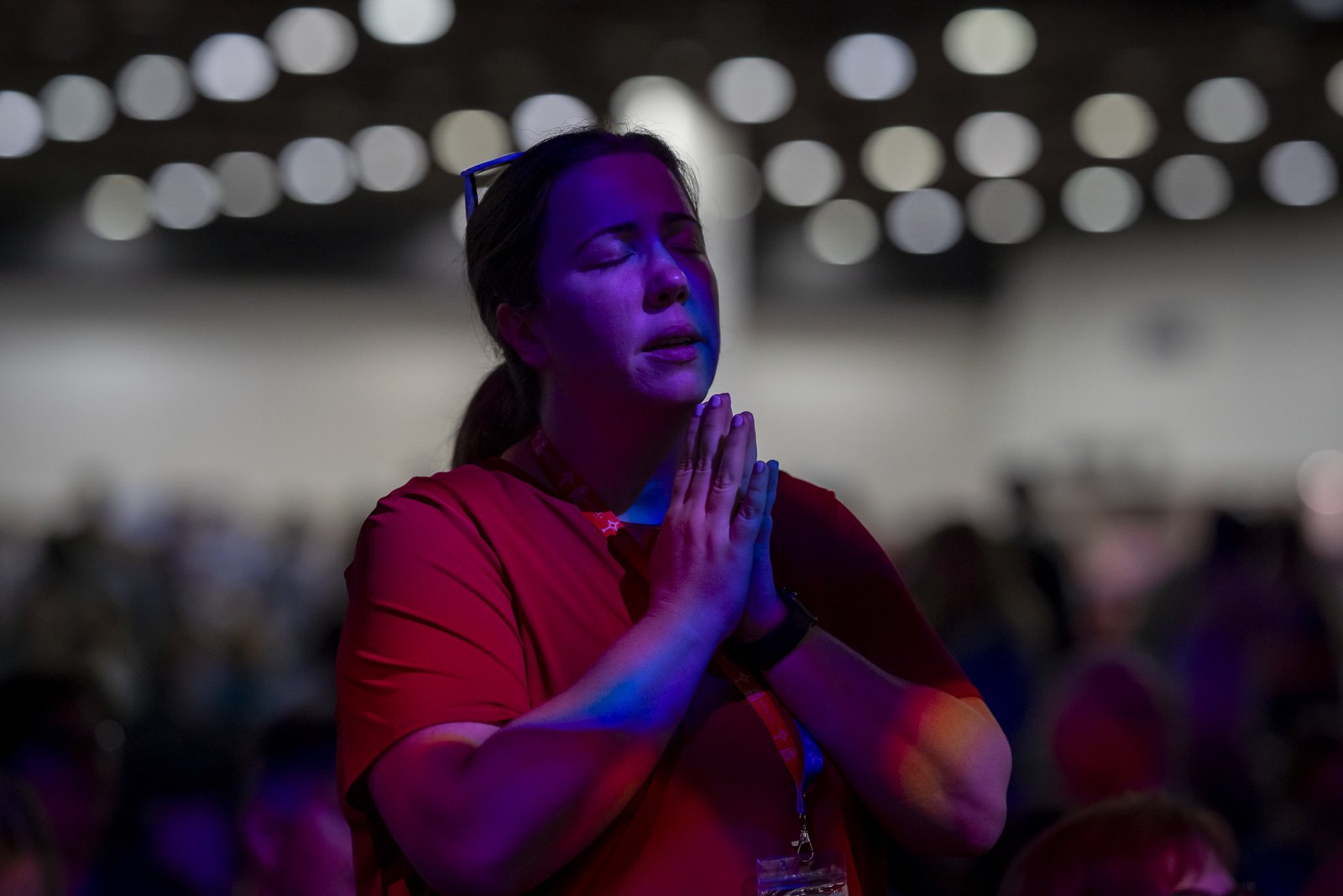 A woman prays during praise and worship at the start of the "Rising from the Ashes" Revival at downtown Detroit's Huntington Place. (Valaurian Waller | Detroit Catholic)
