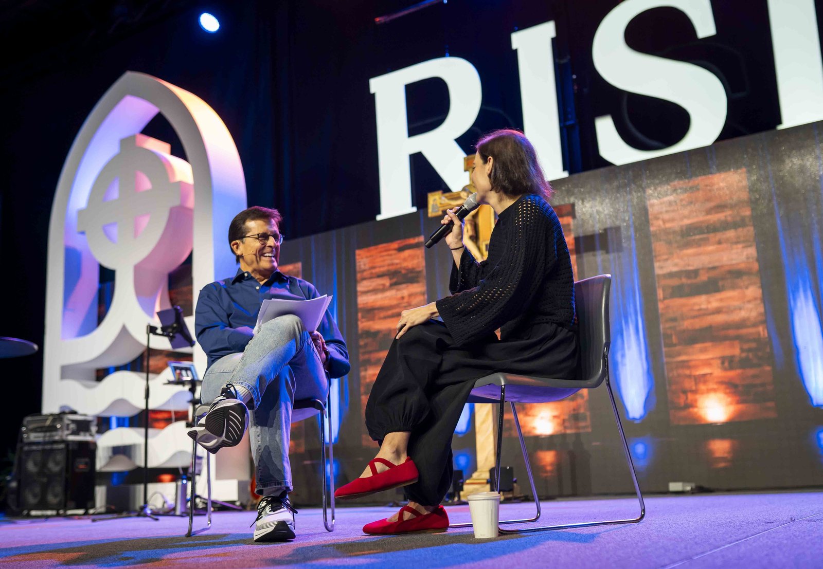 Master of ceremonies and former Detroit TV personality Chuck Gaidica interviews musician Sarah Kroger during a "fireside chat" portion of the revival. (Valaurian Waller | Detroit Catholic)