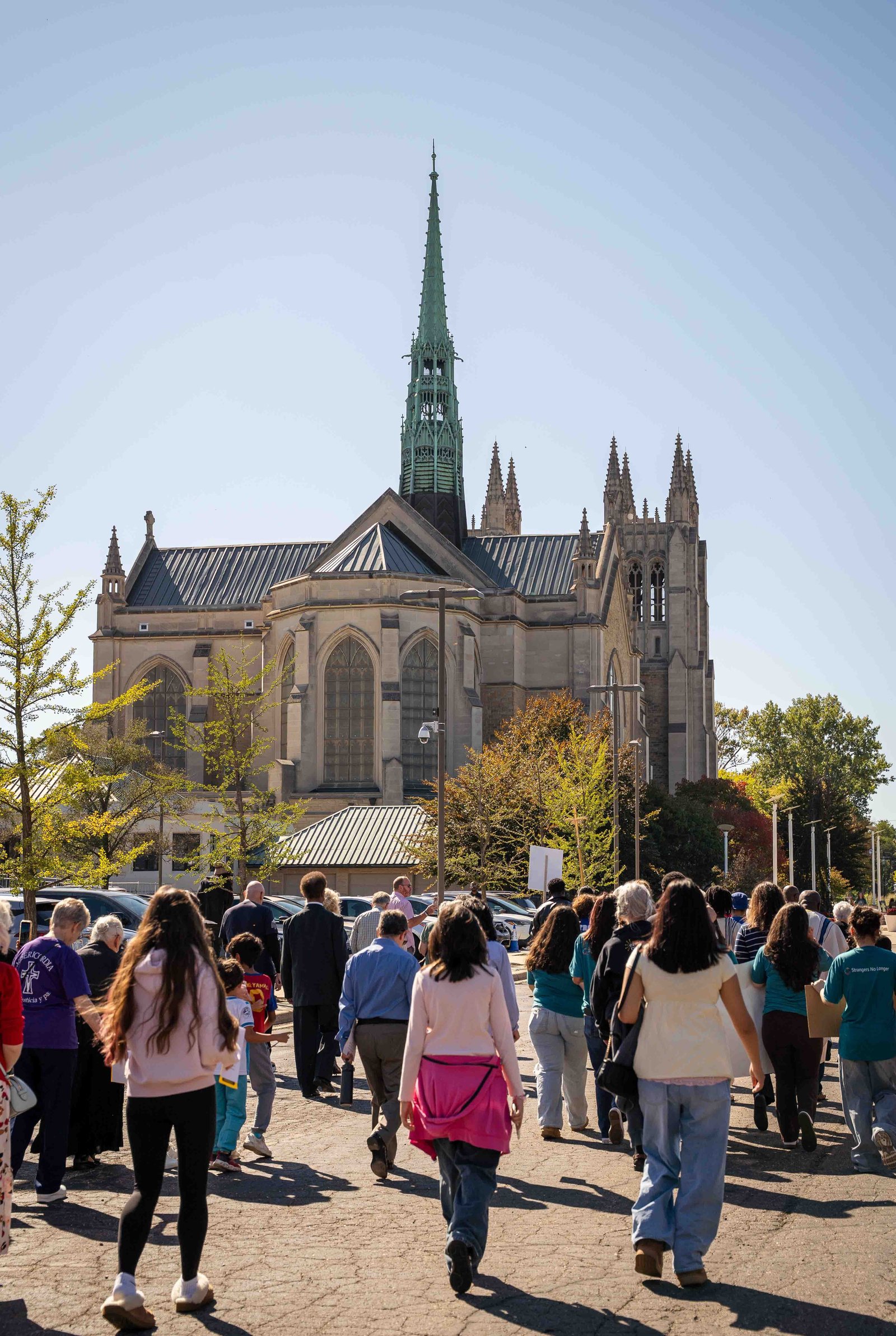 Varias personas participan en una procesión por los terrenos de la Catedral del Santísimo Sacramento antes de la misa de la Jornada Mundial del Migrante y del Refugiado el 4 de octubre. Se pidió a los participantes reflexionar sobre la difícil situación de quienes han sido deportados, detenidos o asesinados en encuentros con el Servicio de Inmigración y Control de Aduanas (ICE) en el último año y medio.