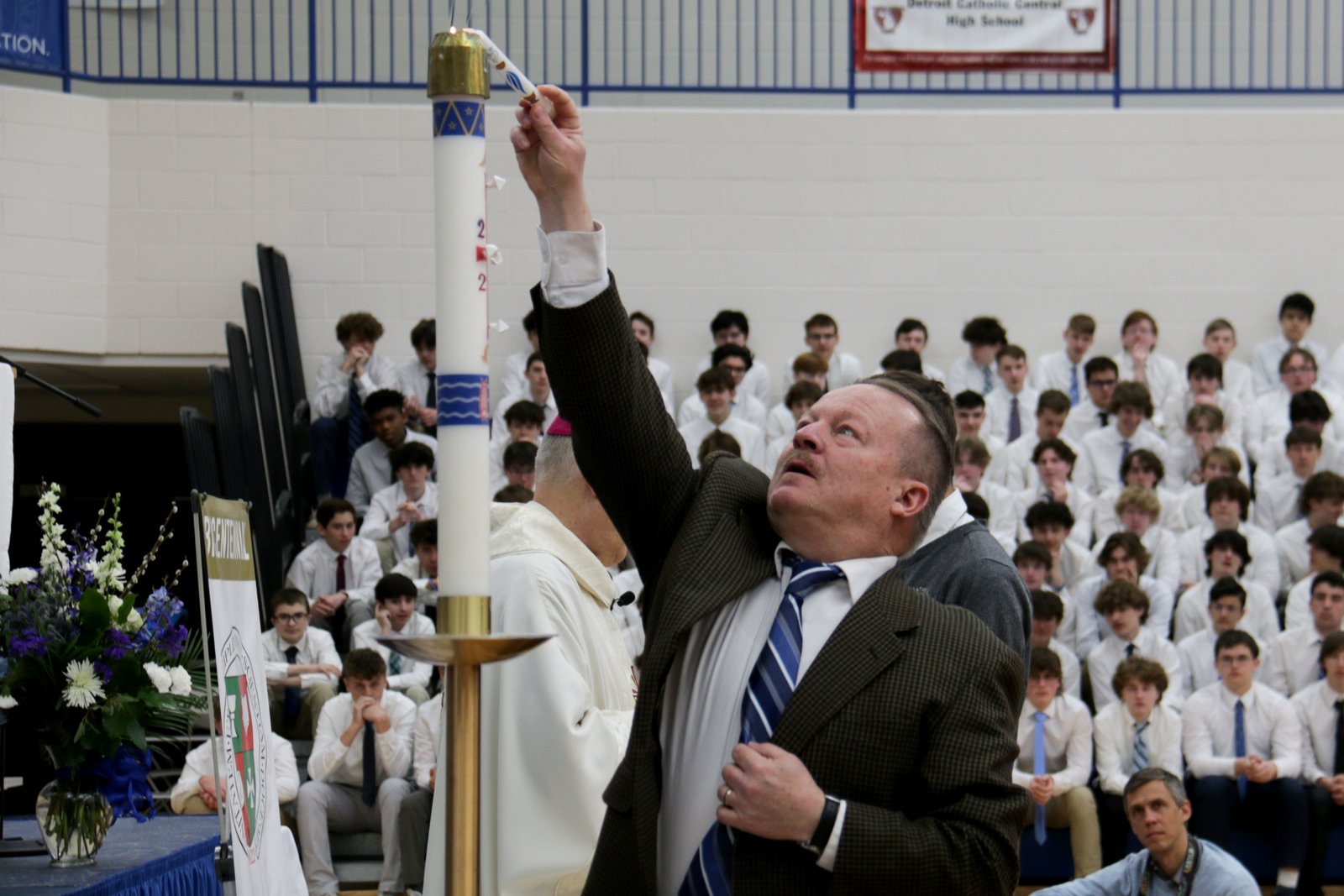 Paul Stuligross, profesor de teología en la escuela preparatoria St. Mary's en Orchard Lake, enciende el cirio pascual durante la misa en la Central Católica. Stuligross dijo que la clase de teología es un lugar perfecto para conocer a los estudiantes en el punto en que se encuentran en su fe.