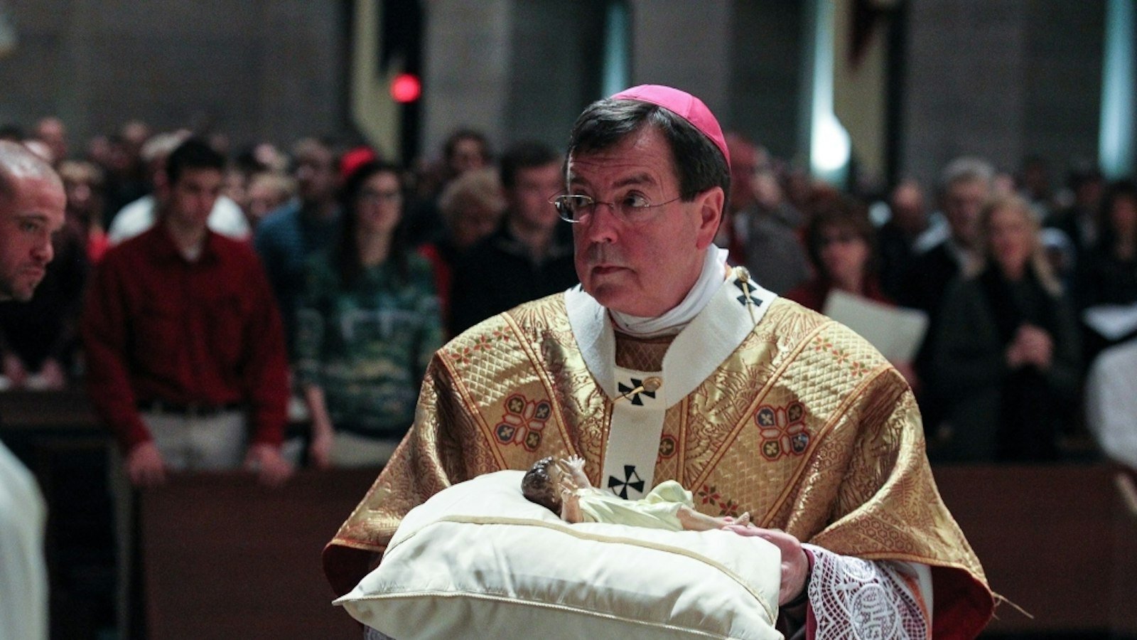 El Arzobispo Vigneron lleva al Niño Jesús al pesebre durante la Misa de Gallo en Nochebuena, el 24 de diciembre de 2012, en la Cathedral of the Most Blessed Sacrament. (Larry A. Peplin | Detroit Catholic file photo)