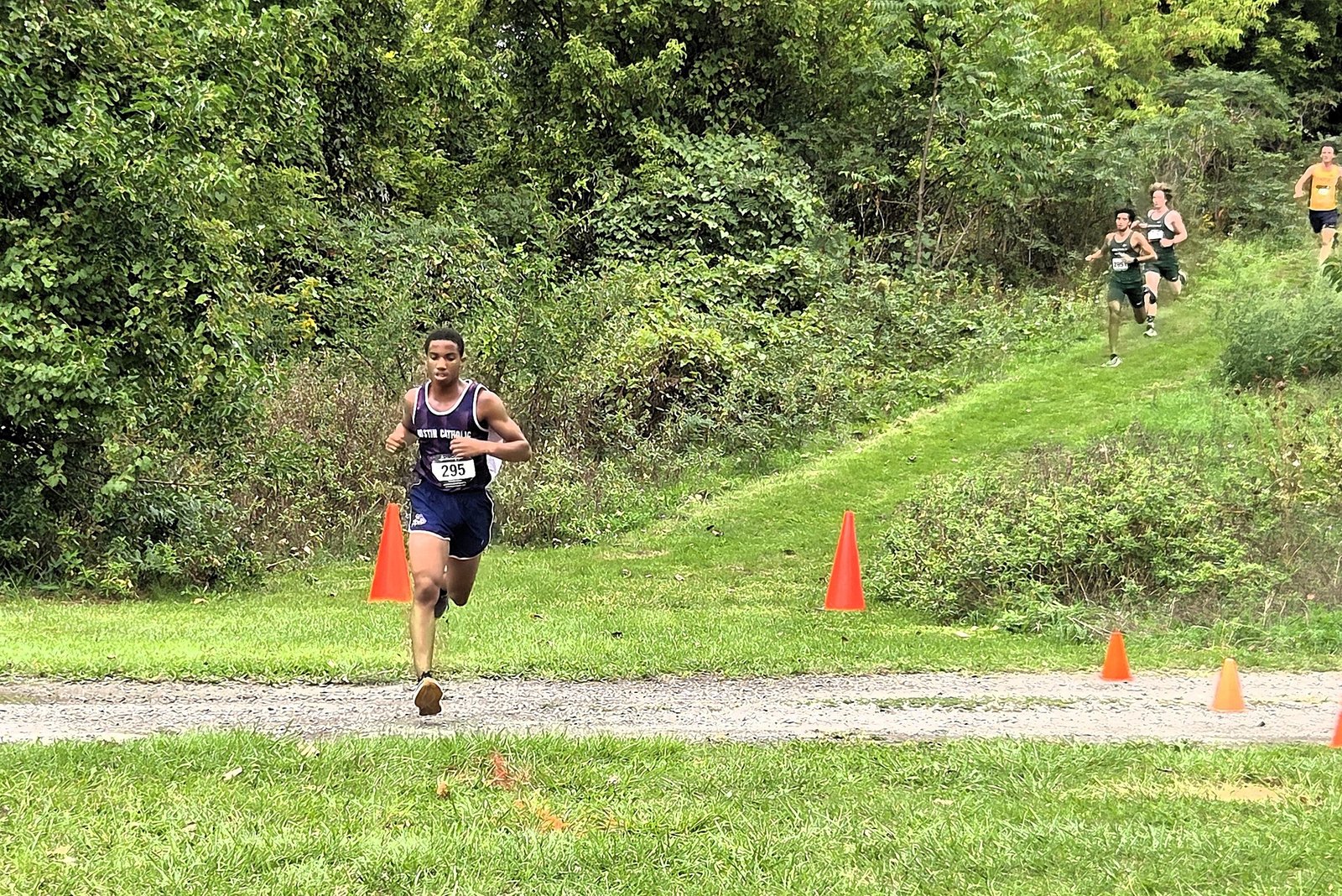Gavin Bowers leads the field down the hill halfway through the Catholic League’s first Cardinal Division jamboree on Sept. 16. He held off several challengers to finish first in the race hosted by Detroit Cristo Rey at Fort Wayne.