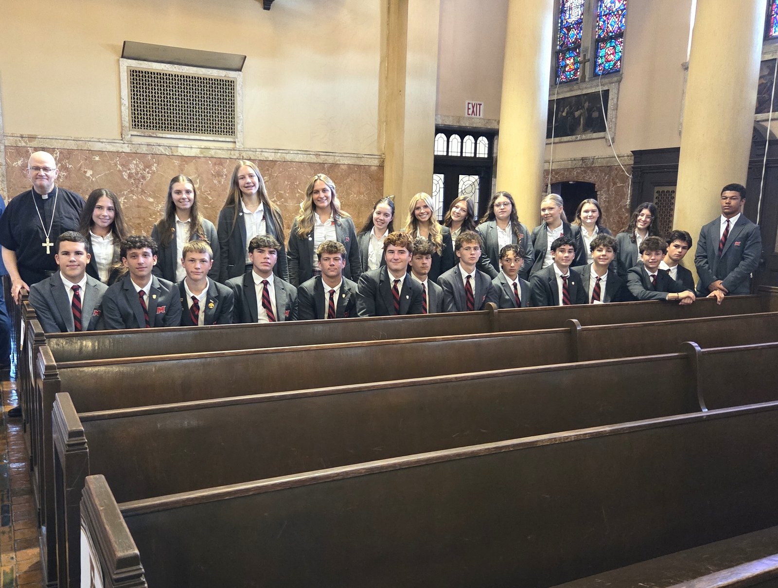 Archbishop Edward J. Weisenburger joins student-athletes from Cardinal Mooney Catholic High School in Marine City prior to the Mass.