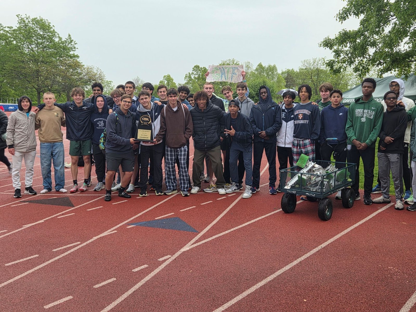 The Ann Arbor Greenhills boys team celebrates their championship title at the Catholic League St. Anne Division meet on their home track. The Gryphons won every race 800 meters or more, accumulating 199 points.