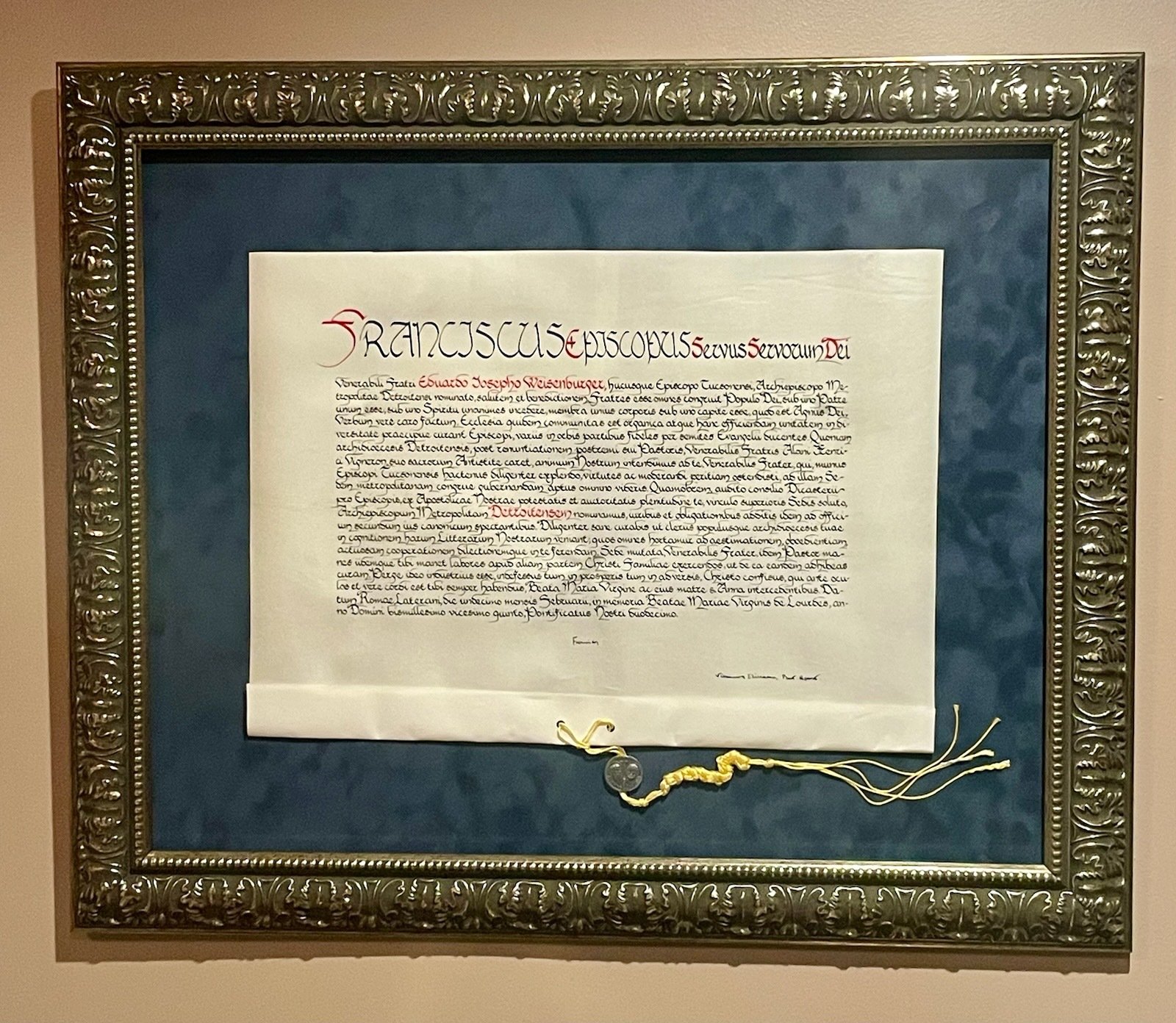 After a wait of about two weeks following his Mass of Installation, Archbishop Edward J. Weisenburger received his papal bull of appointment as Archbishop of Detroit. The document has since been mounted, framed, and now hangs in his office at the archdiocesan Chancery.

The term “papal bull” refers to a formal document issued by the pope, often addressing matters such as doctrine, governance, and appointments to major offices. The word “bull” derives from the Latin "bulla," referring to the lead seal traditionally affixed to authenticate the document. Since the 12th century, such leaden seals have been standard for papal bulls, although on particularly solemn occasions, a gold seal was sometimes used. In more recent times, a red wax seal bearing the image of the bull is typically used, but for bishop appointments, the ancient custom of the lead seal (bulla) is still observed.

A papal bull can be signed only by the pope. Because of Pope Francis’ hospitalization, he was unable to sign Archbishop Weisenburger’s bull in time for his March 18 installation Mass. The archbishop expressed his humility and gratitude that, as the pope’s health improved, he was able to sign a final batch of such decrees, among them, Archbishop Weisenburger’s appointment.