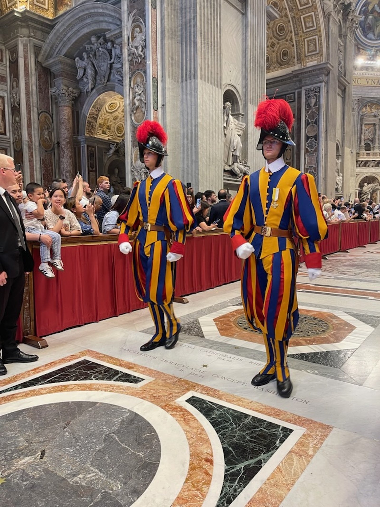 A pair of Swiss Guard process out of St. Peter's Basilica along with the new archbishops and Pope Leo XIV.