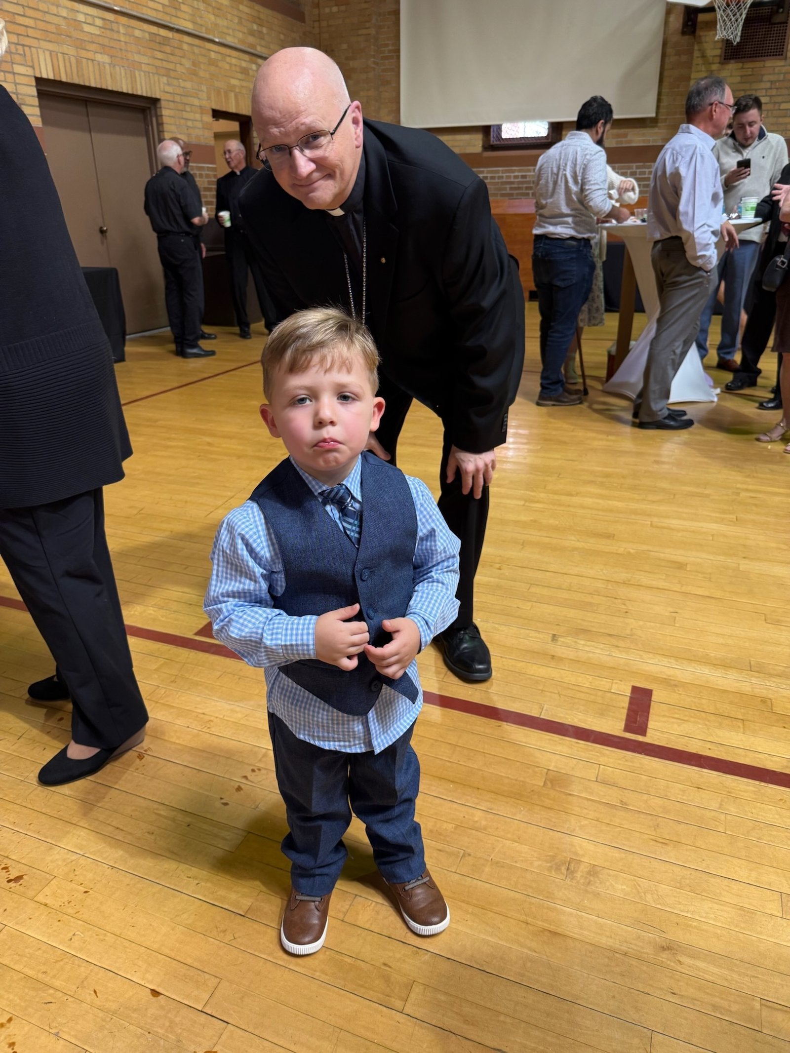 Archbishop Weisenburger smiles for a photo with Deacon John Kovacik's 3-year-old son, Noah.