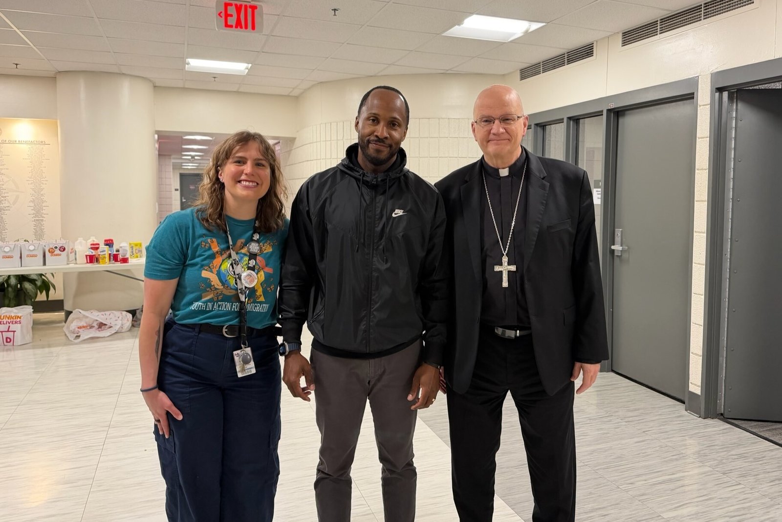 Archbishop Weisenburger joins campus minister Hannah Coley, left, and Edward Maddox, director of programs and community relations at University of Detroit Jesuit High School, which hosted Strangers No Longer's sixth annual Youth Conference on April 17.