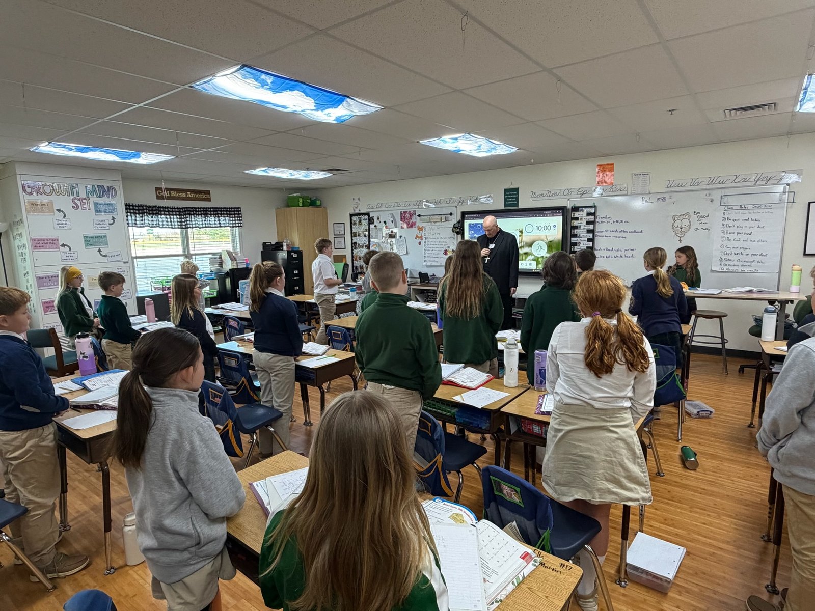 Archbishop Weisenburger leads the classroom in prayer.