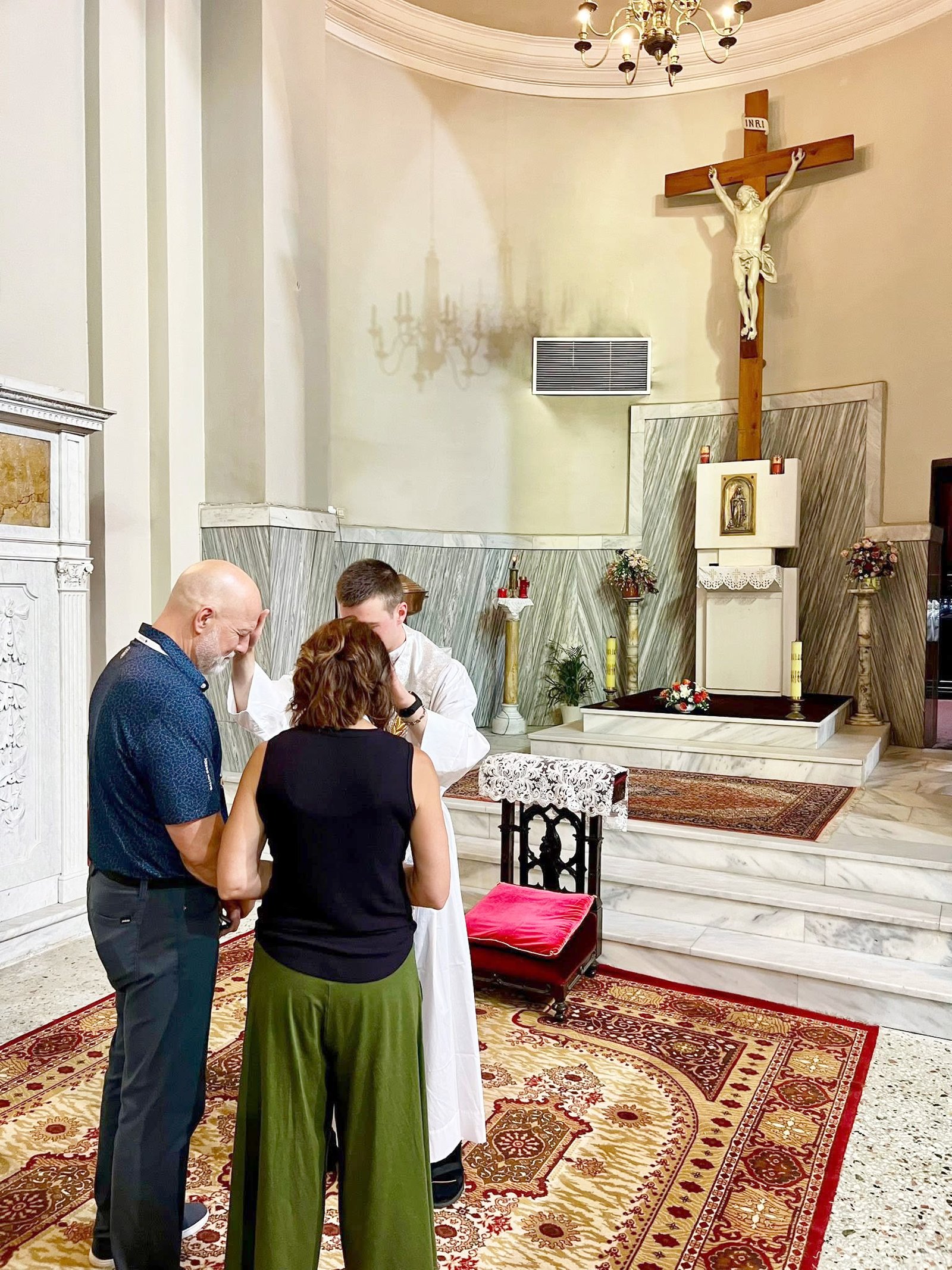 Fr. Karl Finkbeiner blesses a couple following a Mass for pilgrims at the Cathedral of the Immaculate Conception in Thessaloniki, Greece, during a pilgrimage with Corporate Travel Service, ACTS XXIX and the Emmaus Institute team. (Photo via Corporate Travel Service's Facebook page)
