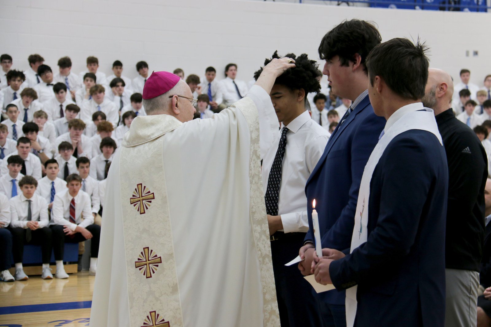 El obispo Hanchon consagra las cabezas de los estudiantes recién confirmados con óleo santo. Aunque la formación está dirigida por profesores de teología, Whitehead cree que los jóvenes se sintieron atraídos por la fe debido a la influencia de sus compañeros de instituto.