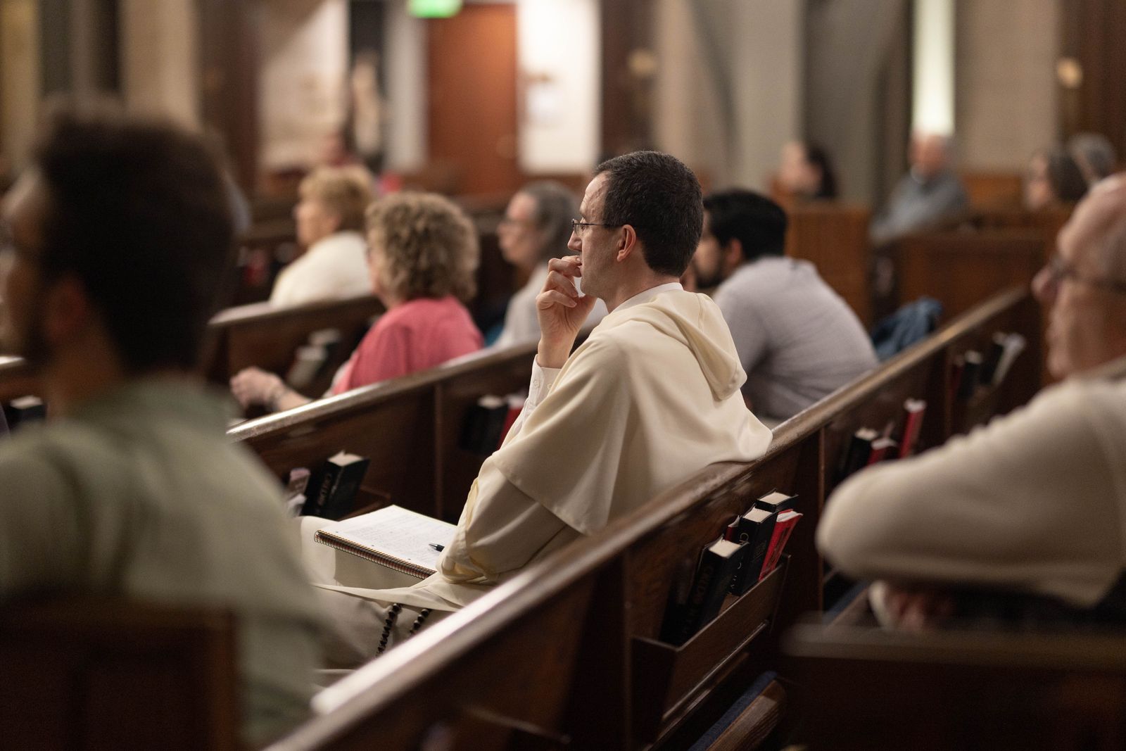 A Dominican friar listens as Archbishop Vigneron delivers a keynote address about St. Thomas Aquinas' Eucharistic theology as it relates to the Eucharist as a "pledge of future glory" and a sure sign of the hope that awaits the blessed in heaven.