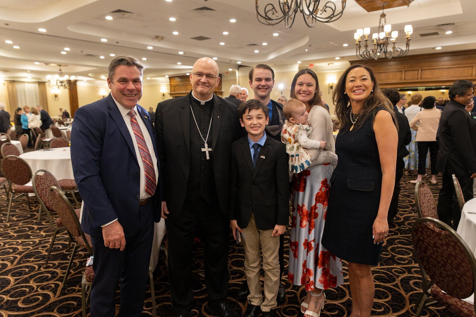 Margo Damoose y su esposo, el senador estatal de Michigan John Damoose, posan para una foto junto al arzobispo de Detroit, Edward J. Weisenburger, y tres de sus cuatro hijos y uno de sus nietos en la 48ª Cena Anual en Defensa de la Vida.