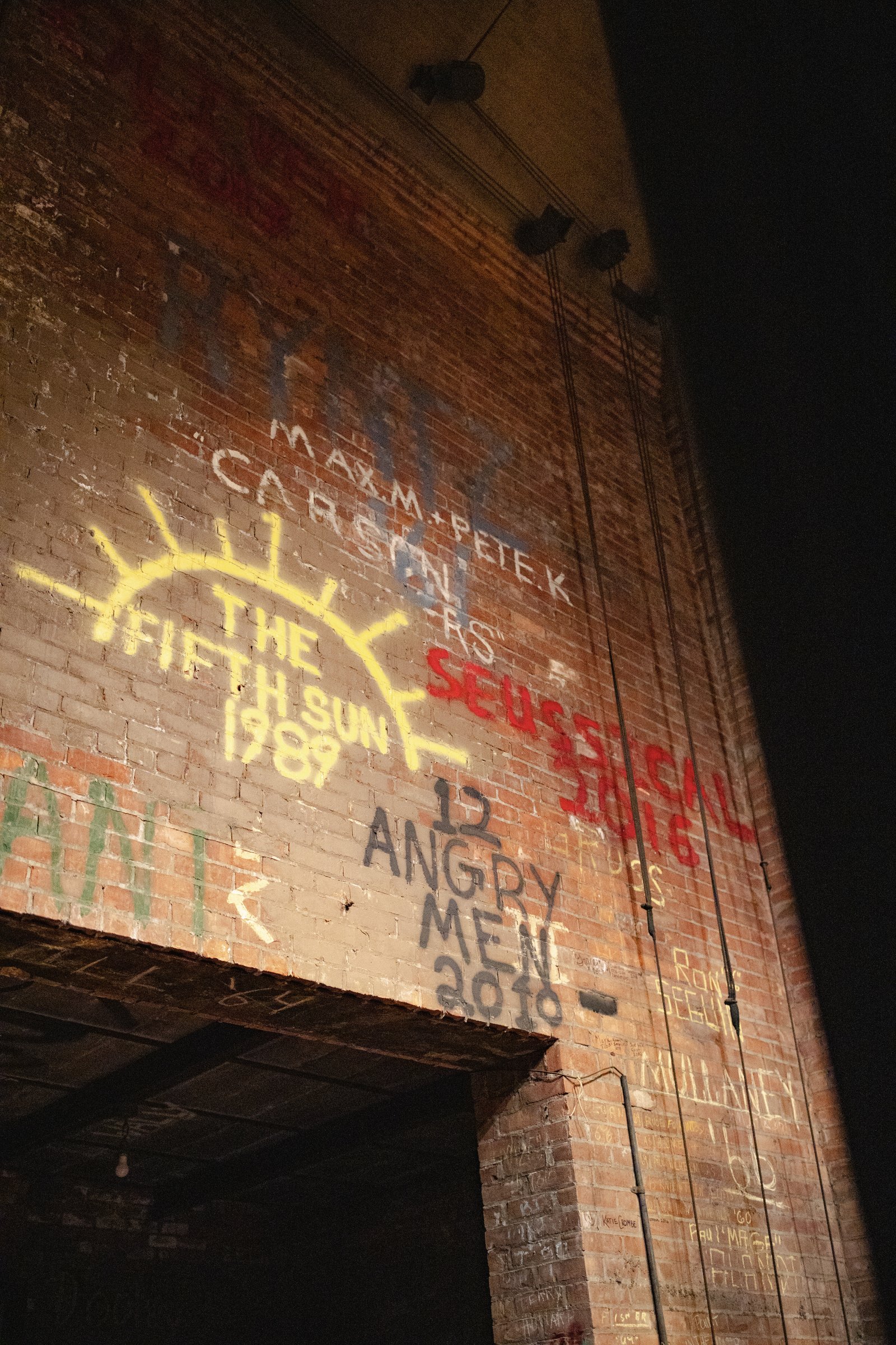 Graffiti on the wall behind the stage includes dates of previous performances, a living relic to Sacred Heart's rich theatrical past.
