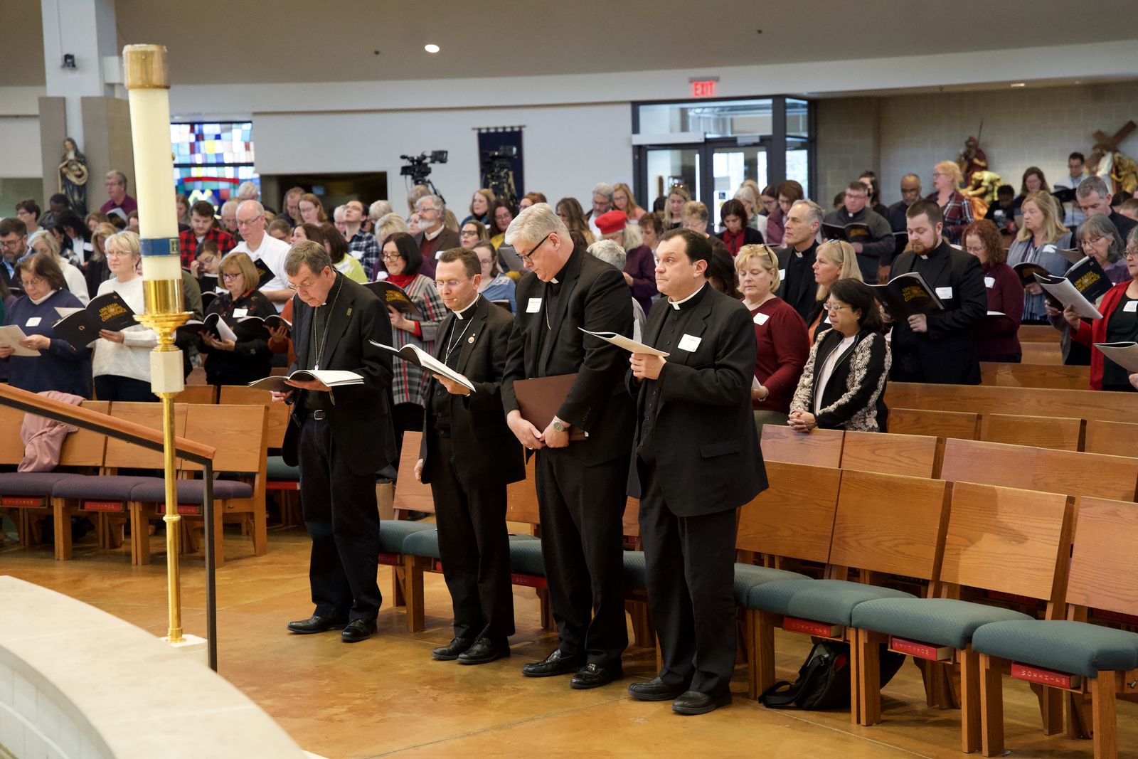 From left, Detroit Archbishop Allen H. Vigneron, Bishop Andrew Cozzens of the Diocese of Crookston, Minn., Detroit Auxiliary Bishop Gerard W. Battersby and Fr. Jeffrey Day, moderator of the curia for the Archdiocese of Detroit, lead hundreds in prayer during the Unleash the Gospel Conference on Nov. 18 at Our Lady of Good Counsel Parish in Plymouth.