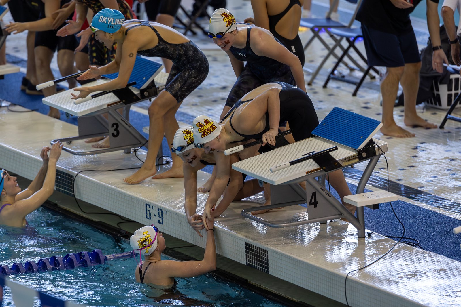 Mackenzie Conway, Campbell Shore and Leah Graves congratulate anchor swimmer Avery Tack after Farmington Hills Mercy won the state championship in the 200-yard freestyle relay. The Marlins also won the overall team title for the first time since 2019.