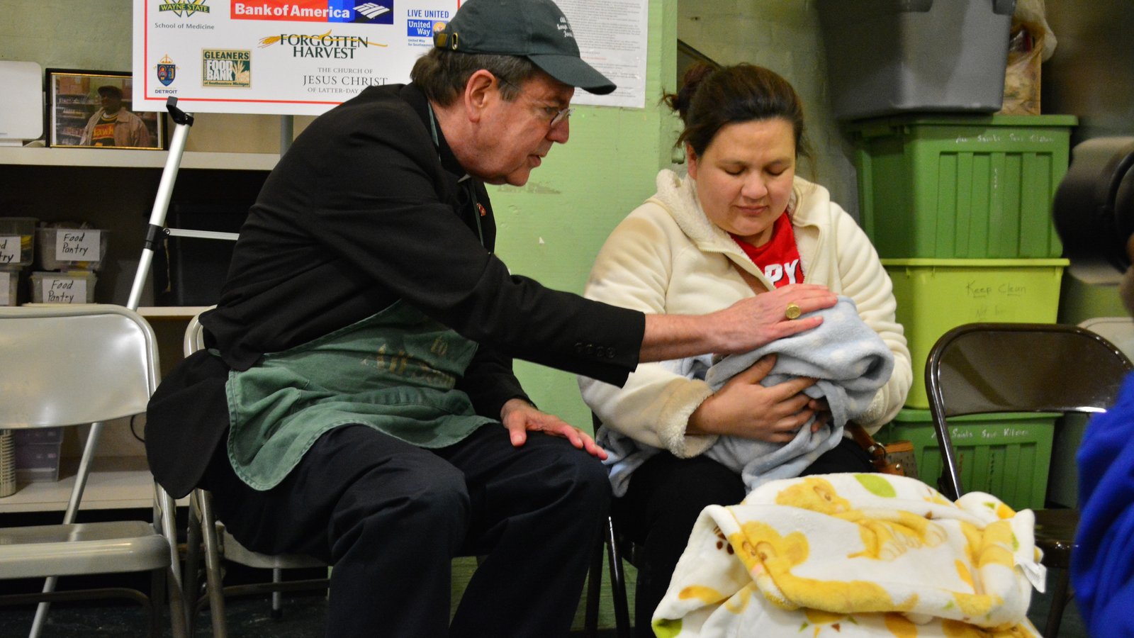 Archbishop Vigneron blesses a newborn infant and his mother while volunteering at All Saints Soup Kitchen and Food Pantry in southwest Detroit during Lent on Feb. 13, 2018. (Michael Stechschulte | Detroit Catholic file photo)