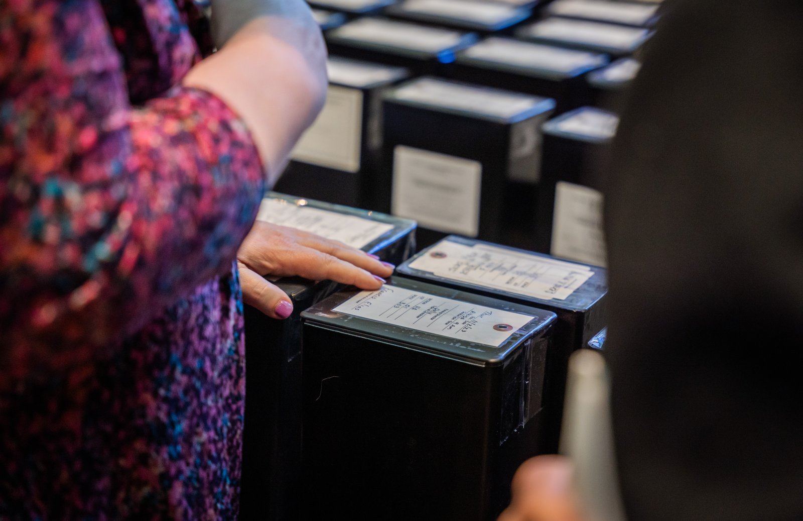 A woman touches an urn containing the cremated remains of a family member Nov. 2 during a Mass and burial service at Holy Sepulchre Cemetery in Southfield.
