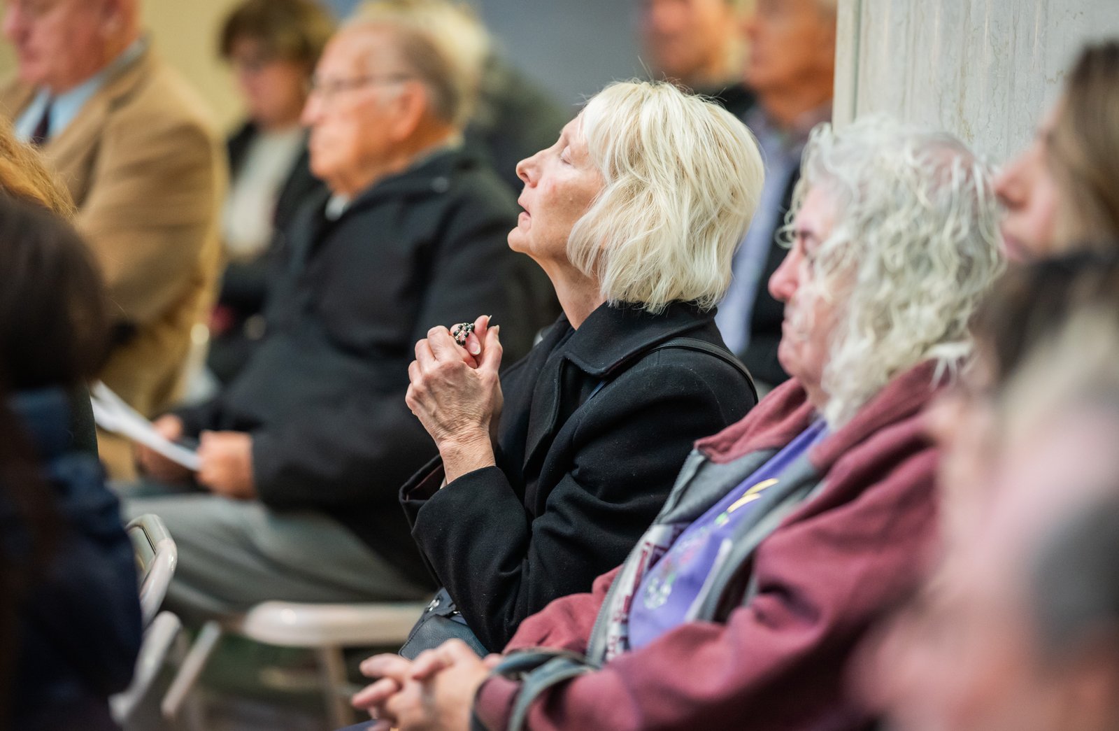 Family members pray for the souls of their deceased friends and relatives during the All Souls Day Mass. Archbishop Vigneron emphasized the importance of praying for those who've gone before, adding the faithful on earth can help them toward their heavenly homeland.