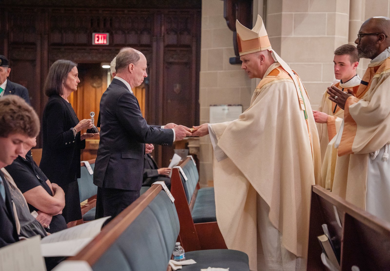 Archbishop Edward J. Weisenburger receives the gifts of the altar during the funeral Mass for Archbishop Michael J. Byrnes. Archbishop Weisenburger offered his condolences to Archbishop Byrnes' family members, reminding all gathered of the victory won in Christ.