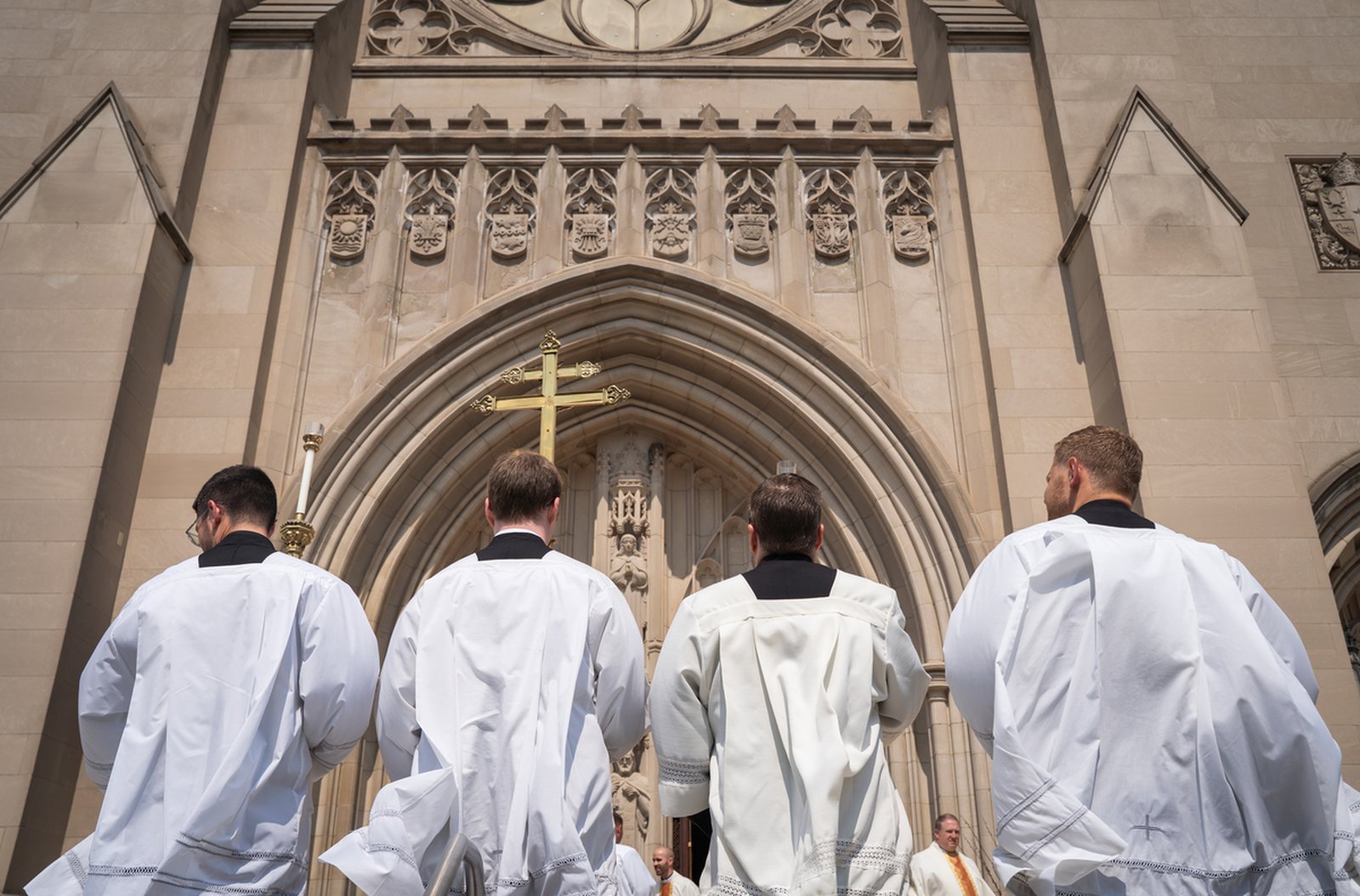 Altar servers kneel as clergy, laity, friends and family bid their final farewell to Archbishop Michael J. Byrnes.