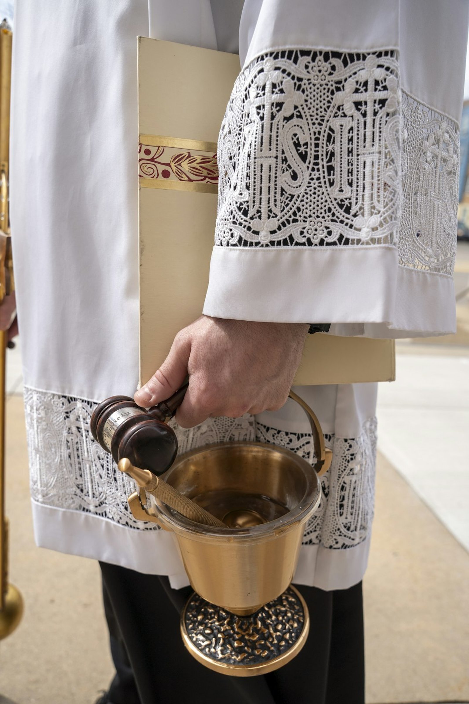 El P. Derik Peterman sostiene un mazo y agua bendita, que el Arzobispo Weisenburger utilizó durante el rito de apertura de la Misa de instalación. (Valaurian Waller | Detroit Catholic)