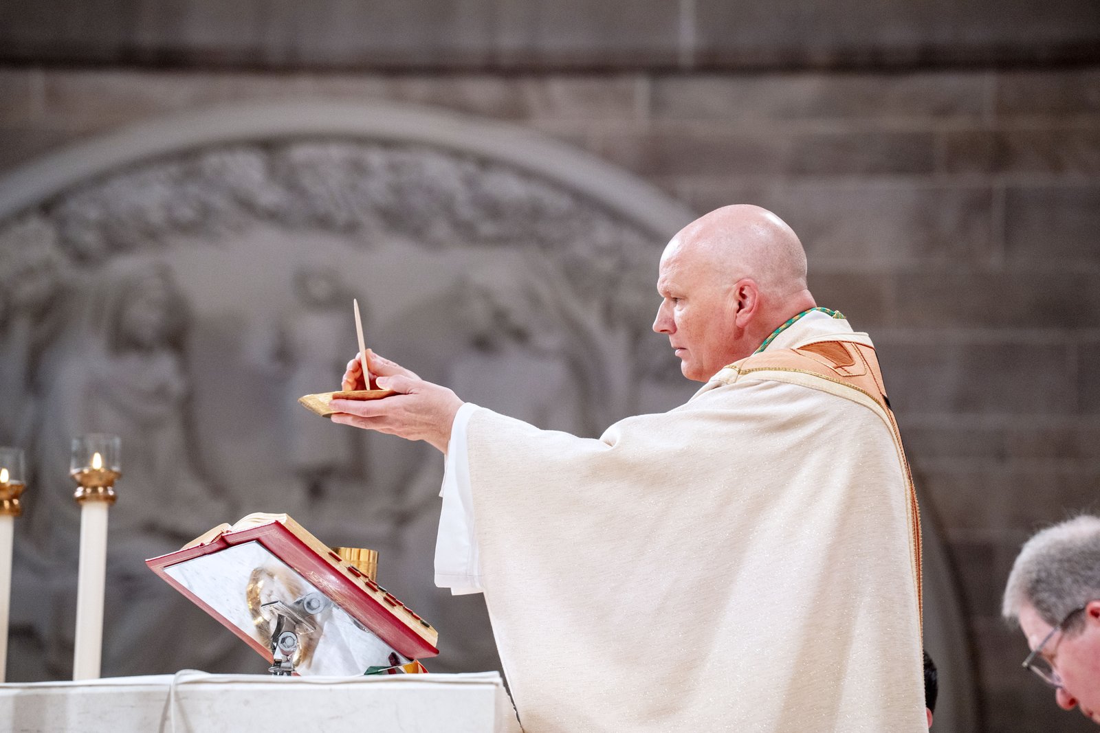 Archbishop Edward J. Weisenburger elevates the Eucharistic host during the holy sacrifice of the Mass during his installation liturgy as the sixth archbishop of Detroit. "Behold the Lamb of God, who takes away the sins of the world," the new archbishop said, echoing his episcopal motto, which comes from St. John the Baptist's prophetic words about the coming of the messiah. (Valaurian Waller | Detroit Catholic)