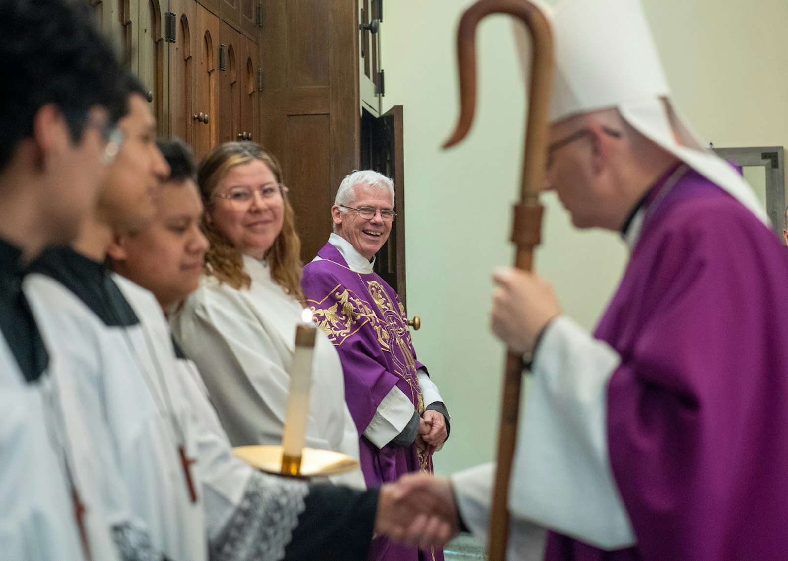 El P. Tony Blount, SOLT, sonríe mientras el Arzobispo Weisenburger saluda a los monaguillos antes de la Misa en la Holy Redeemer Parish de Detroit el 20 de marzo.