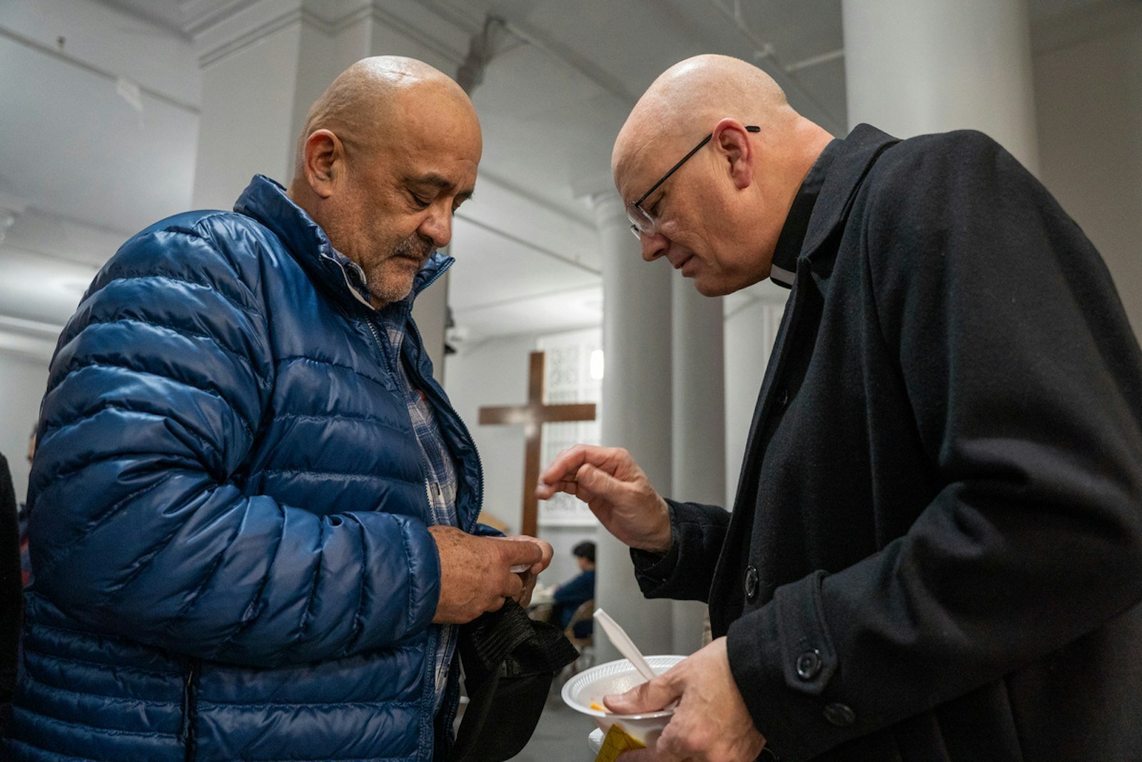El Arzobispo Weisenburger bendice a un hombre durante una recepción después de la Misa.