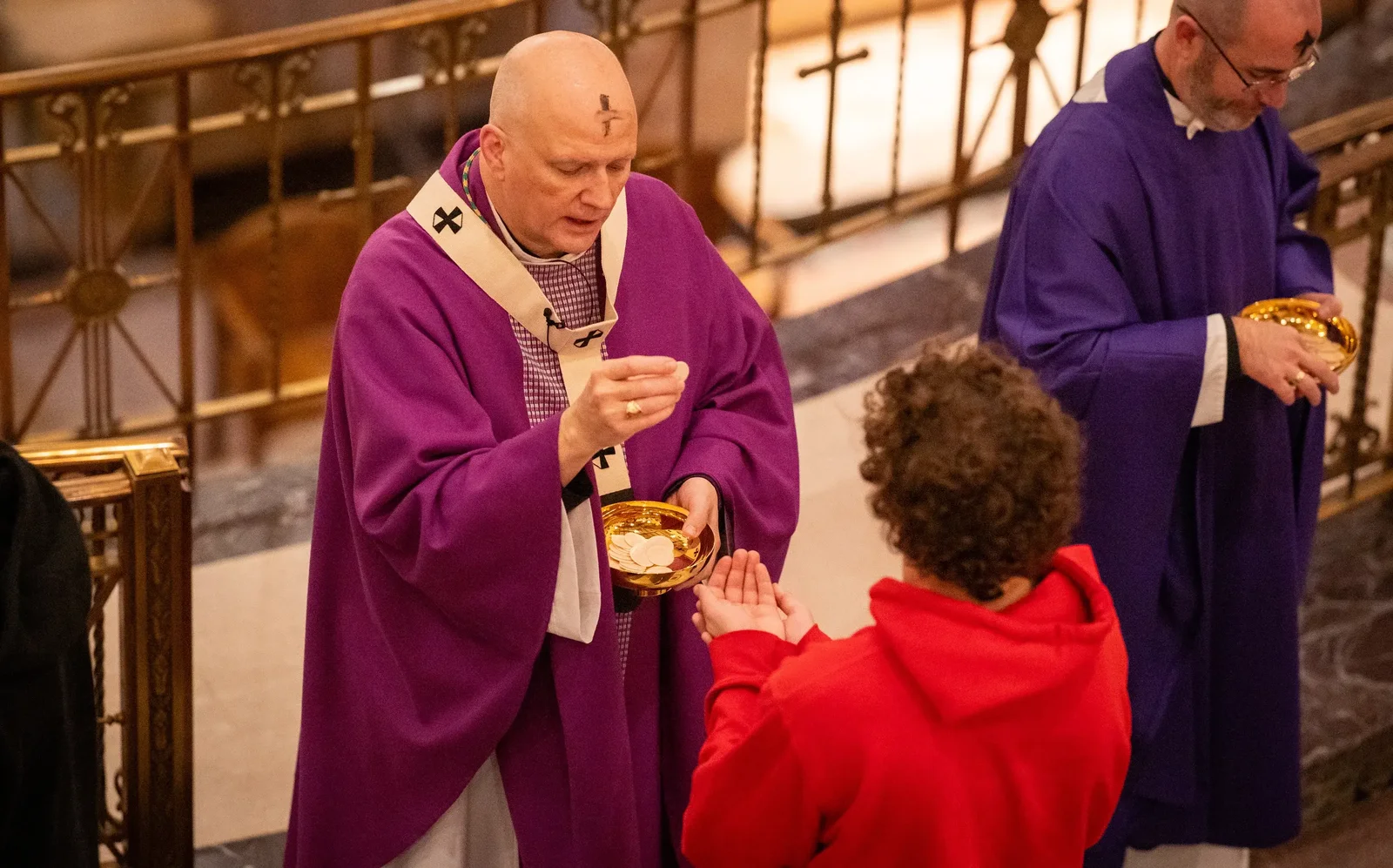 Archbishop Weisenburger distributes Communion during the Ash Wednesday Mass at St. Aloysius Parish in downtown Detroit.