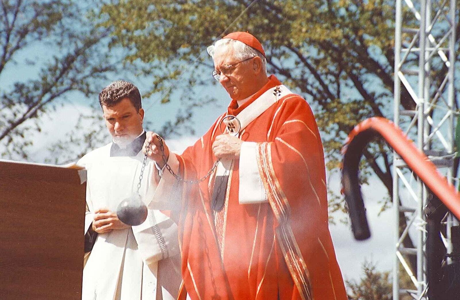 El entonces P. Jeffrey M. Monforton (izquierda) asiste al Cardenal de Detroit, Adam J. Maida en una Misa al aire libre en el St. John's Center en Plymouth durante el Congreso Eucarístico en el año 2000. El Obispo Monforton fue sacerdote-secretario personal del Cardenal Maida durante siete años, dese 1998 hasta 2005, aprendiendo los detalles y aspectos internos de la Arquidiócesis de Detroit y adquiriendo valiosas lecciones sobre el servicio episcopal. (Larry A. Peplin | Detroit Catholic file photo)