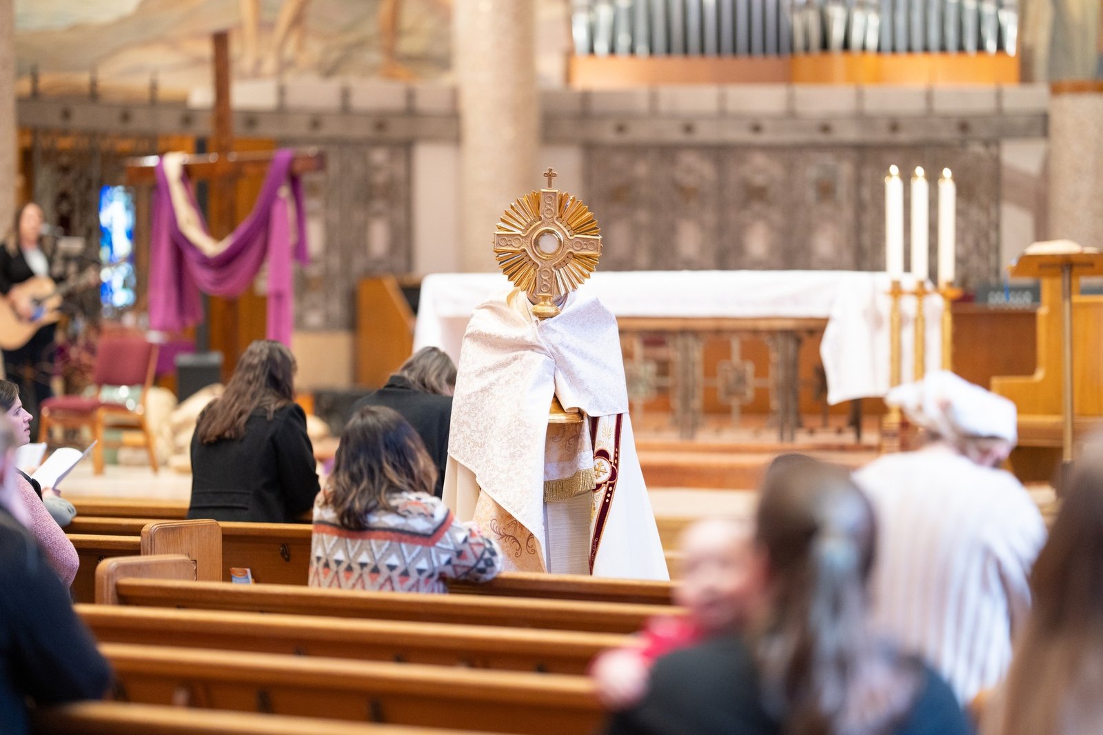 Fr. Brian Meldrum holds up a monstrance with the Blessed Sacrament at the 2025 Behold and Be Held conference. Again this year, the conference will have time for Eucharistic adoration.