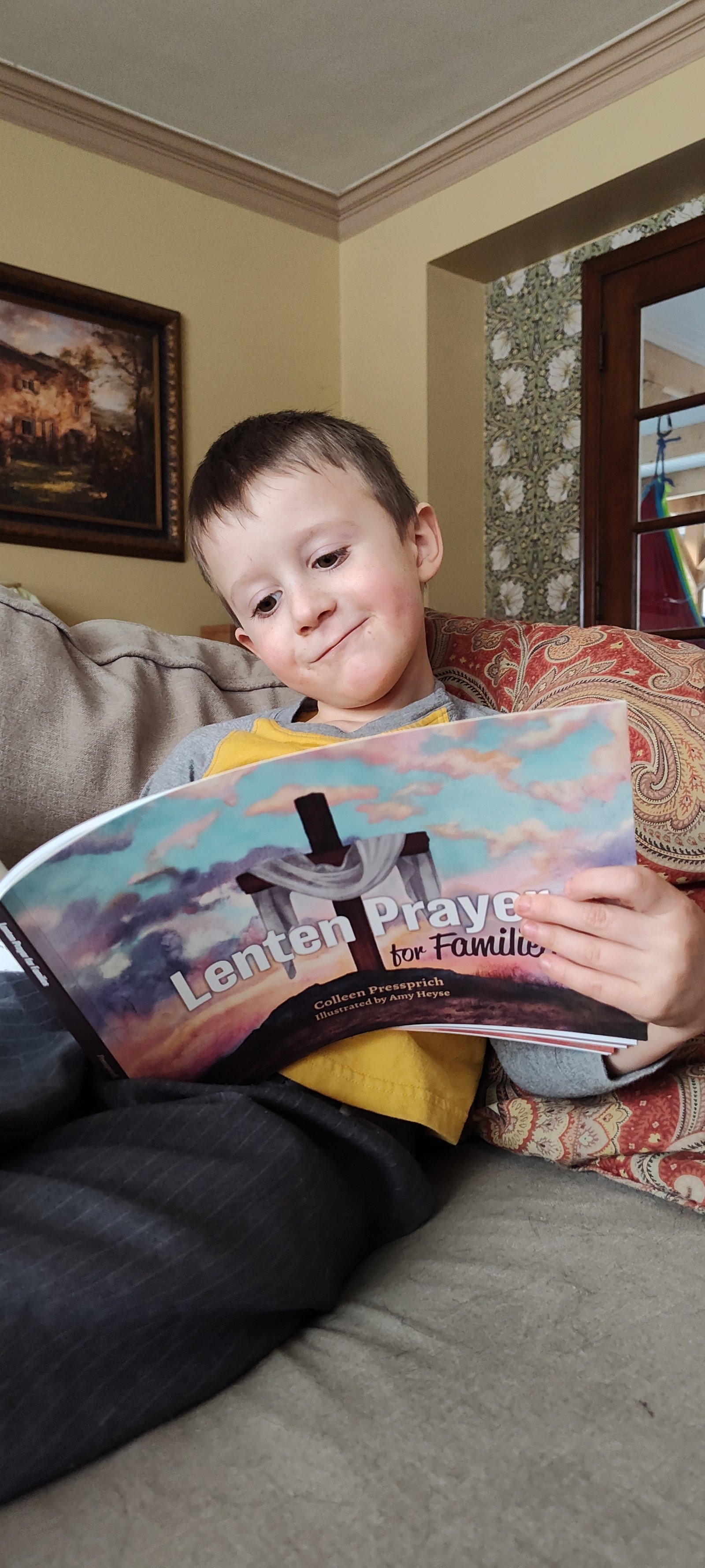 Pressprich's son Ben holds a copy of the book. The family gathers every evening to read and pray together, Pressprich.