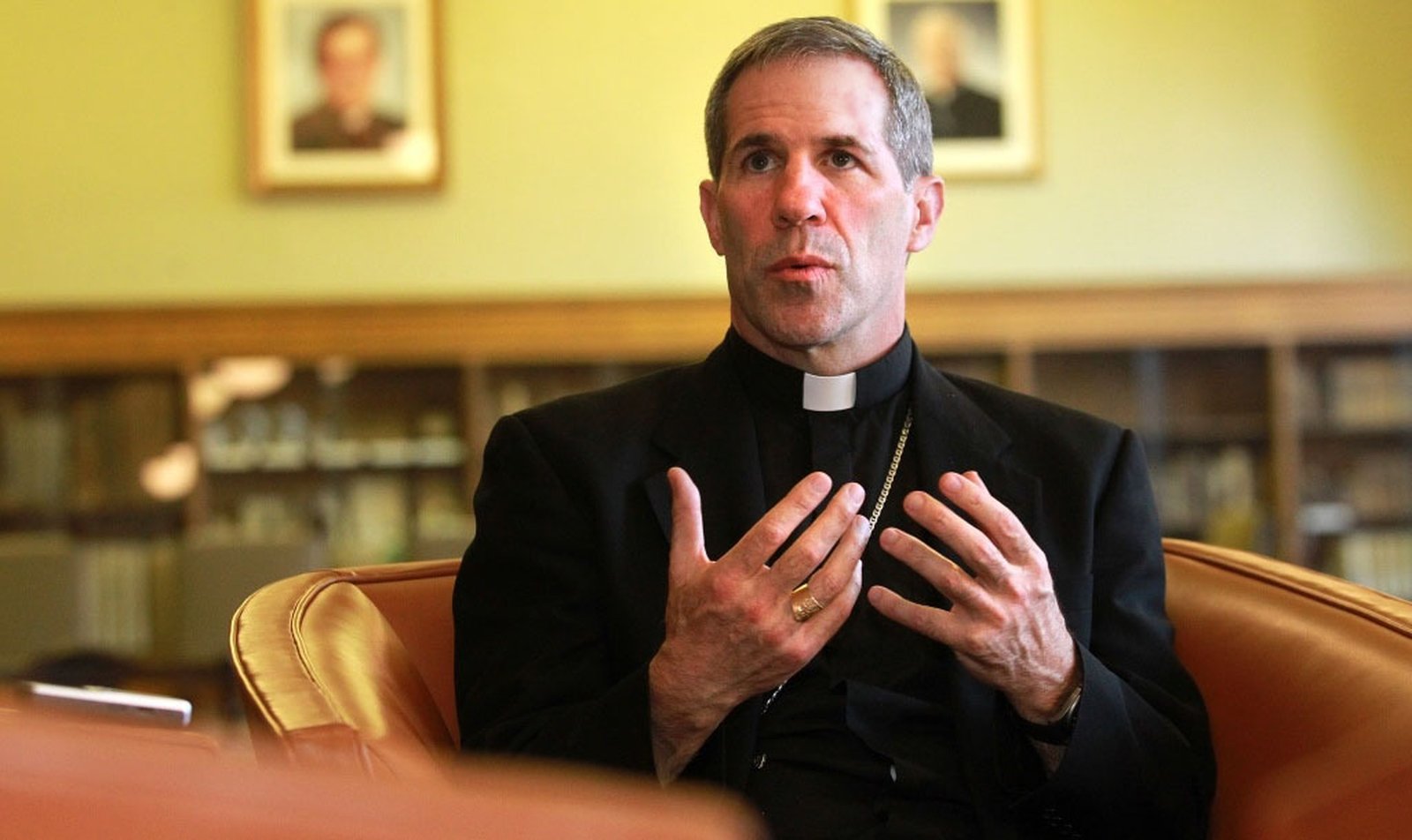 Then-Detroit Auxiliary Bishop Michael J. Byrnes gestures during an interview with The Michigan Catholic newspaper in April 2012 in the Ward Library at Sacred Heart Major Seminary. (Michigan Catholic file photo)
