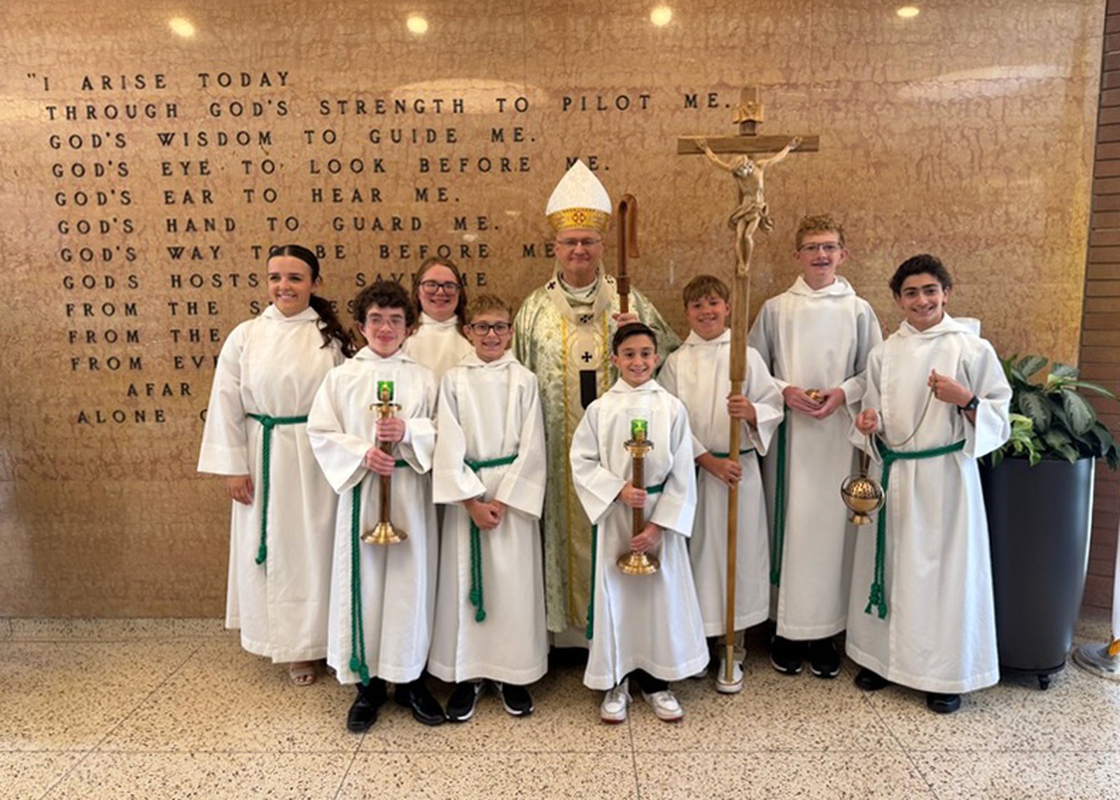 Archbishop Weisenburger poses alongside the young altar servers who assisted during Mass.