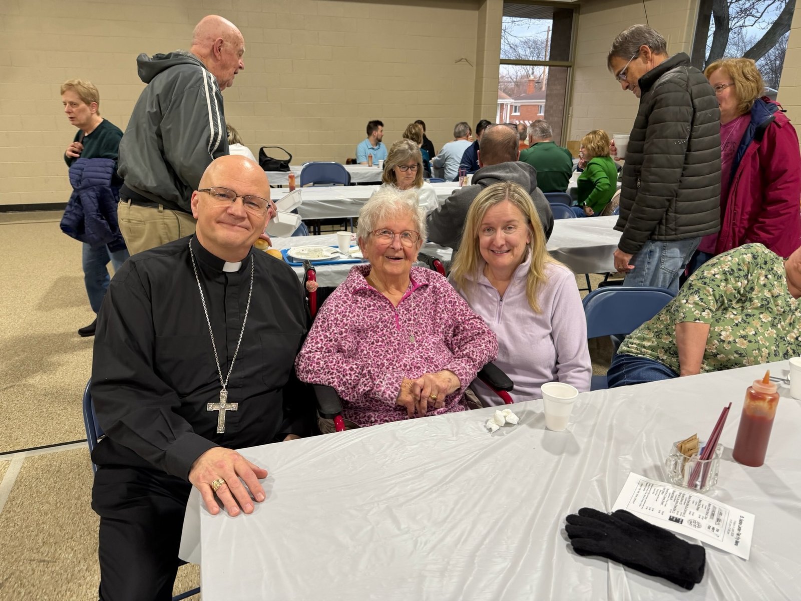 The archbishop joins Elizabeth Stobierski and her mother, Josephine Stobierski, who recently celebrated her 100th birthday, at St. Sabina Parish’s fish fry.