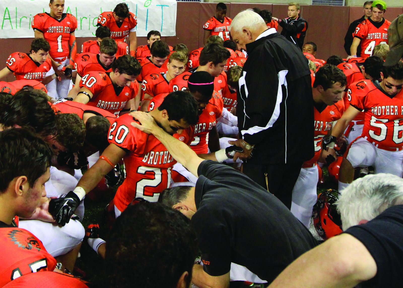 Al Fracassa prays with his Brother Rice football team in the locker room prior to a game. (Photo courtesy of Ken Cendrowski)