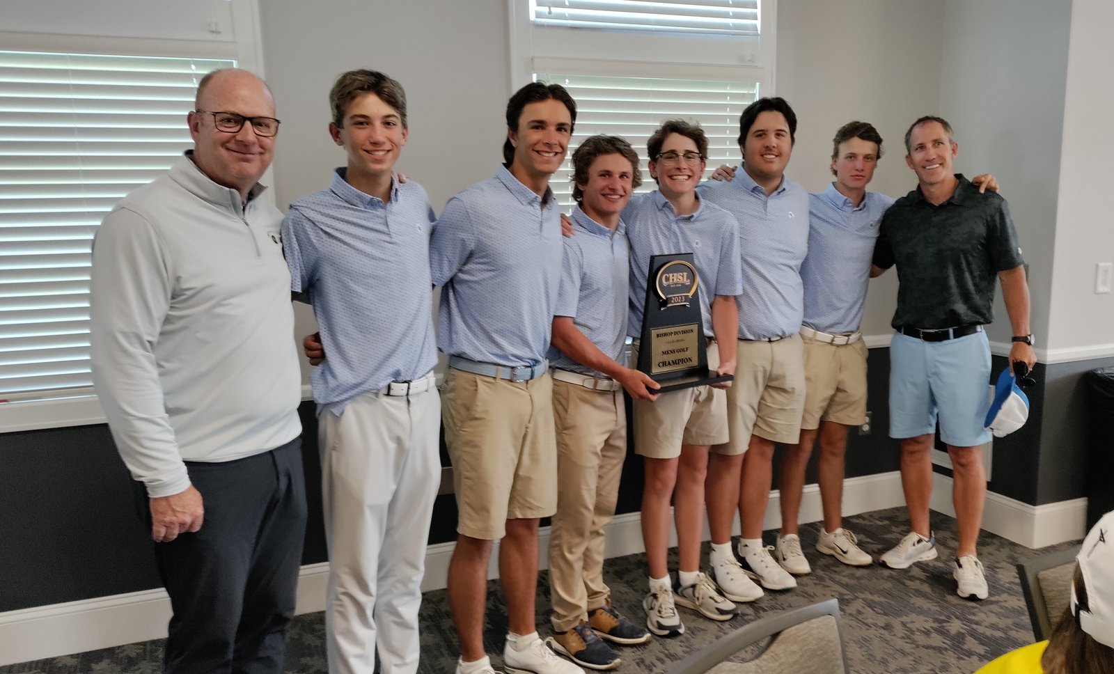 Coach Mike Anderson, left, leads the lineup of Catholic Central golfers celebrating the CHSL boys golf Bishop trophy. That’s David Krusinski, Joe Jarzembowski, Dan Lafferty, Julian Menser, Michael Hermann, Matt Mans and coach Scott Menser. (Photo by Don Horkey | Special to Detroit Catholic)